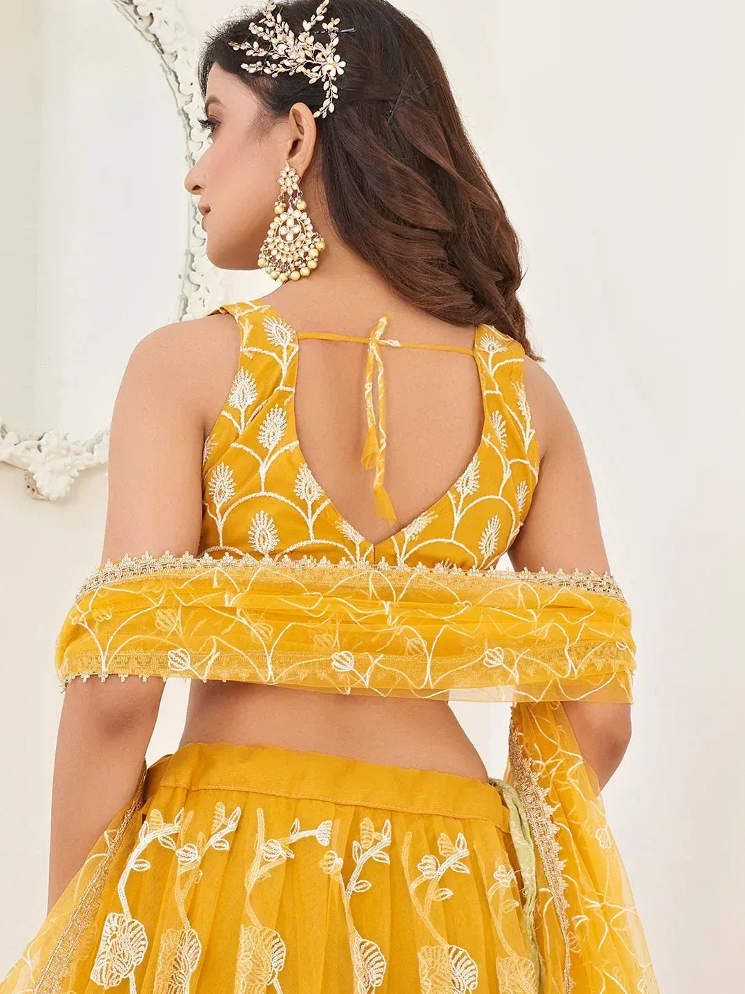 Yellow embroidered lehenga choli with back tie detail, floral motifs, and matching dupatta for Indian ethnic wear