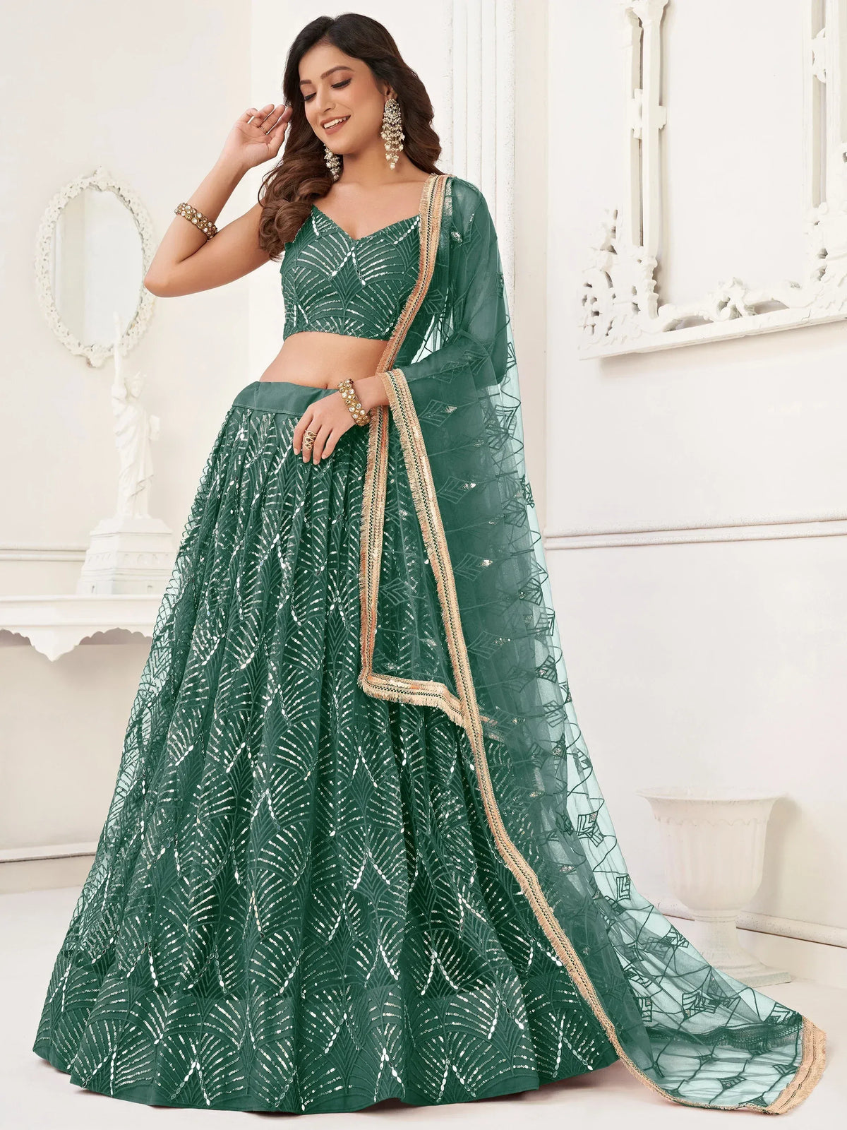 Emerald green designer lehenga choli with sequin leaf pattern and gold trim, perfect for Indian weddings