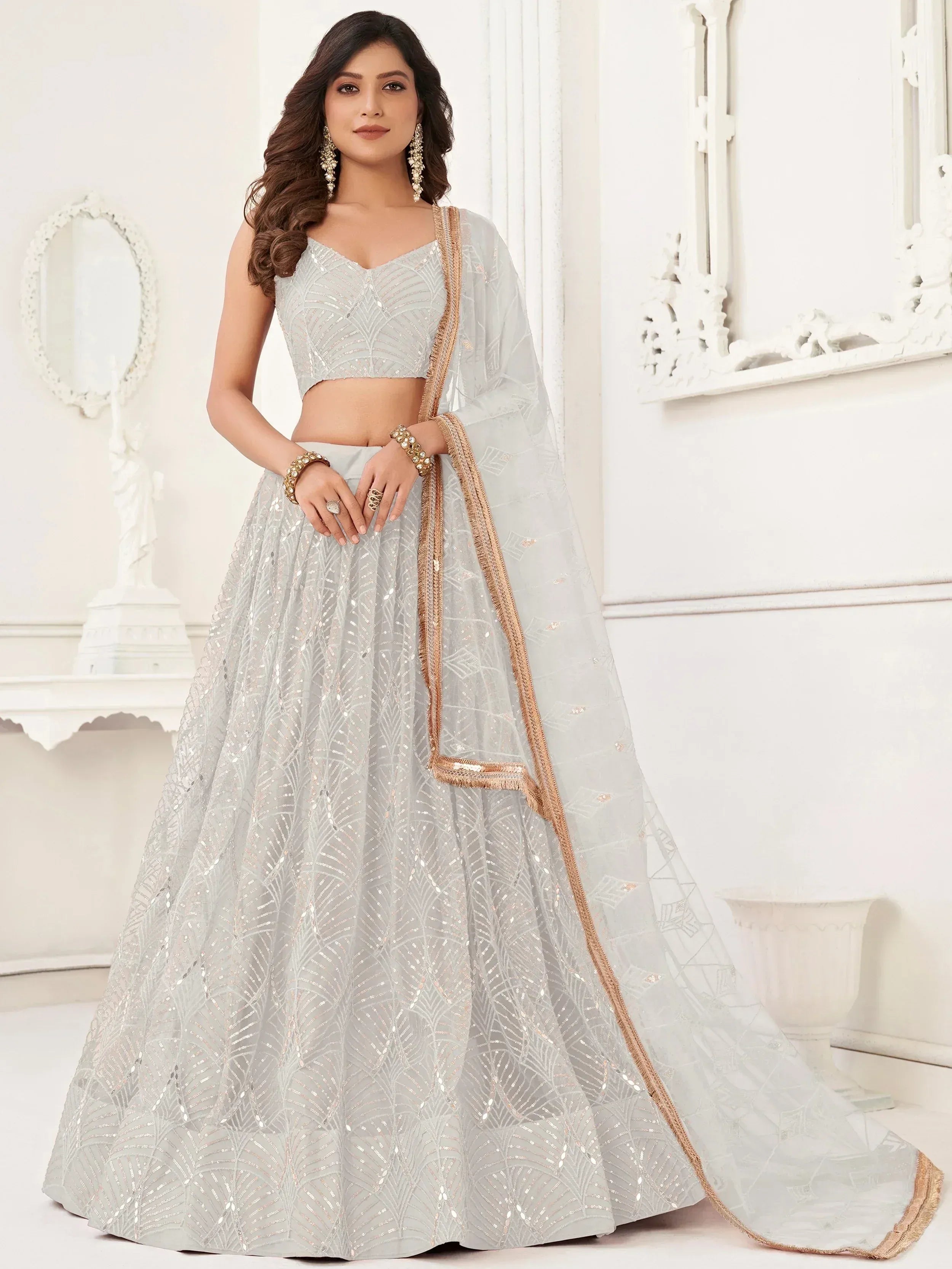 Elegant light grey lehenga choli with sequin embroidery and gold trim, perfect for Indian ethnic occasions