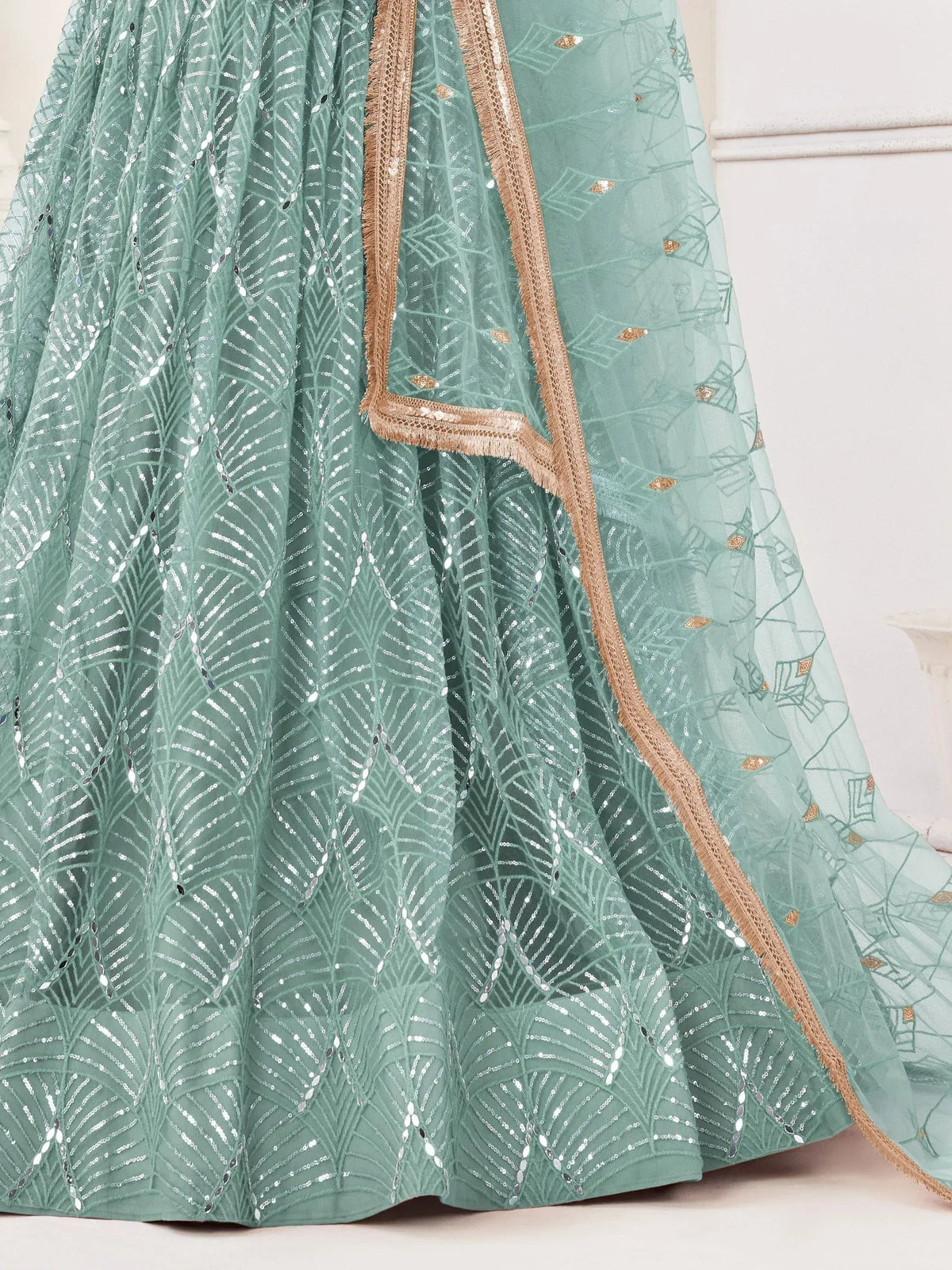 Mint green lehenga with silver sequin leaf patterns and gold trim, ideal for Indian ethnic wear events.