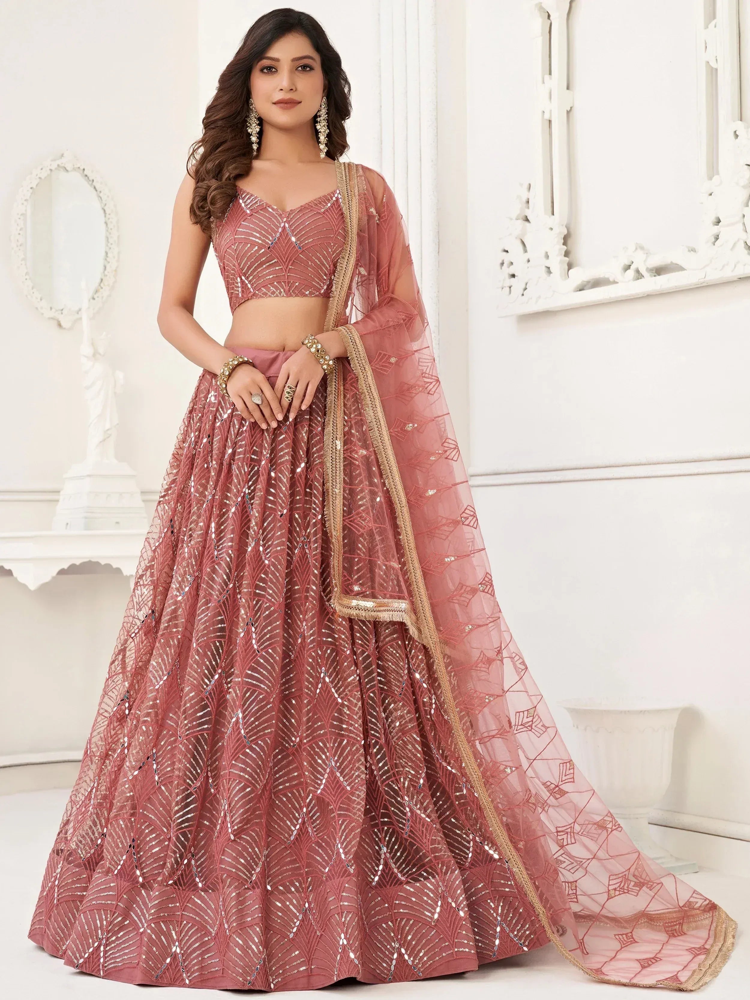 Dusty pink designer lehenga choli with sequin work and gold trim, perfect for Indian weddings and festive occasions.
