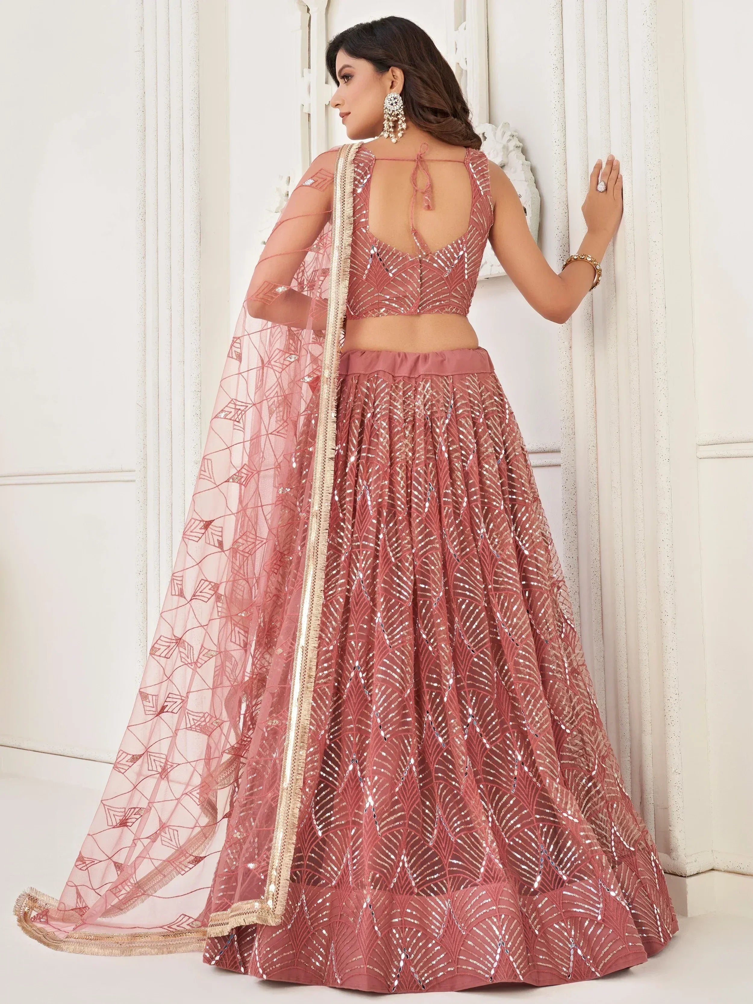 Dusty pink designer lehenga choli with sequin work and sheer dupatta, perfect for Indian weddings and festive occasions.
