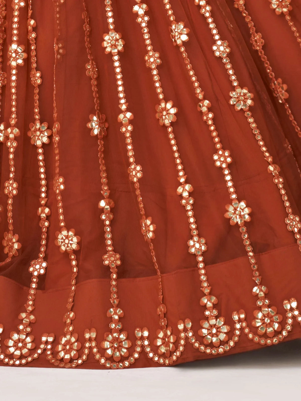 Rust-colored ethnic lehenga with floral mirror work and sequin detailing
