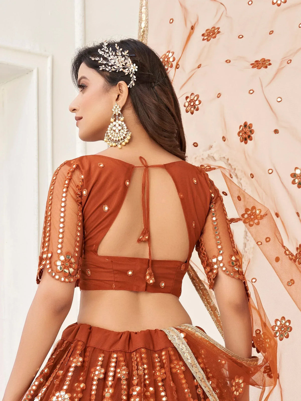 Elegant terracotta lehenga choli with mirror work and sheer sleeves, perfect for Indian ethnic wear