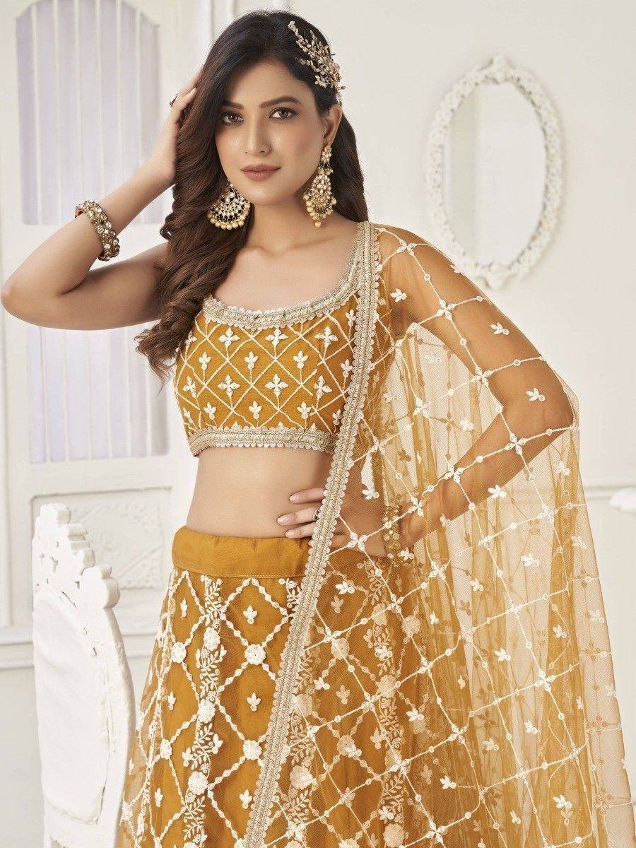 Mustard yellow designer lehenga choli with white floral embroidery and sheer dupatta, perfect for Indian ethnic occasions
