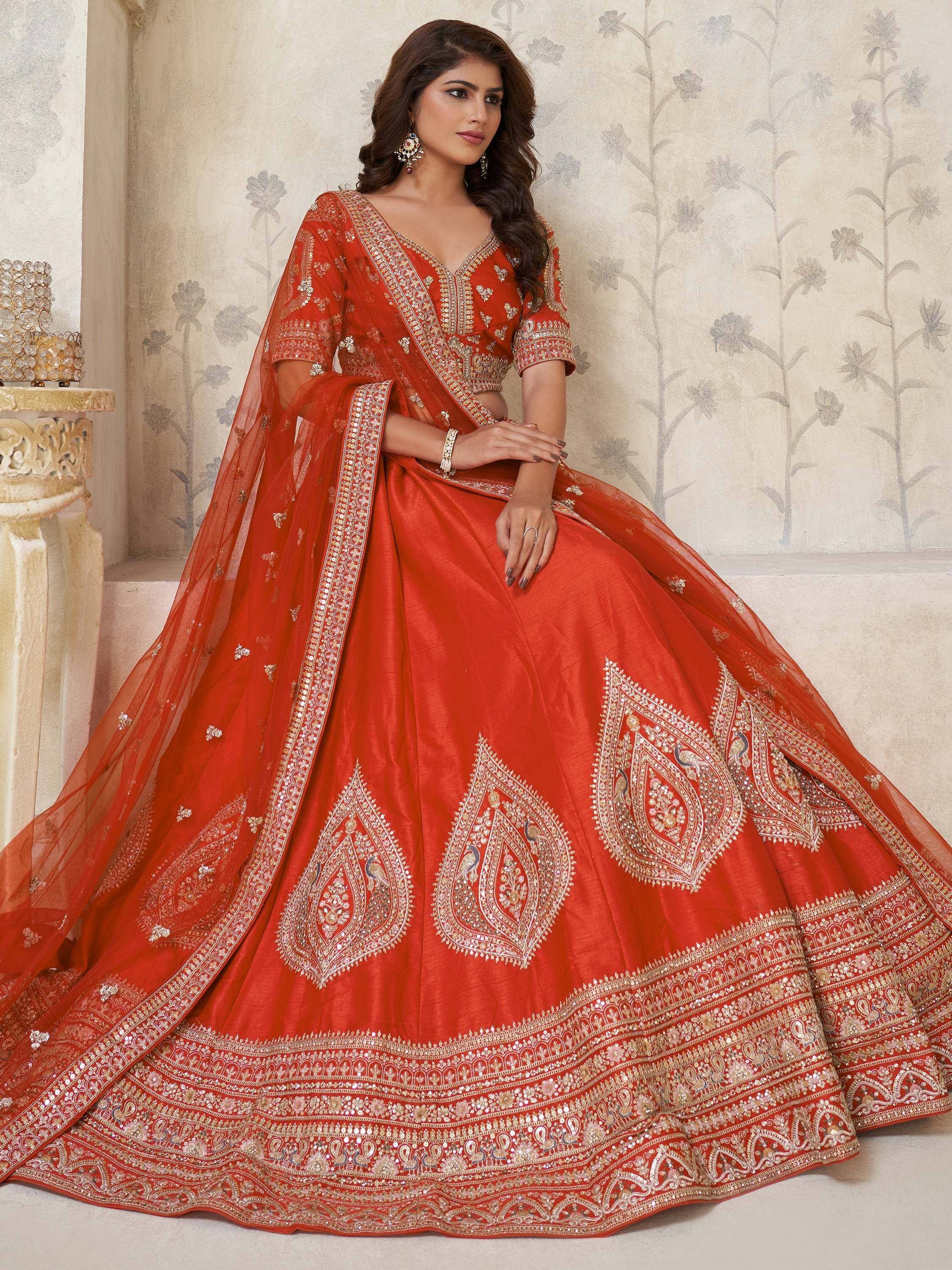 Red designer lehenga choli with gold embroidery and peacock motifs, perfect for weddings and festive occasions.