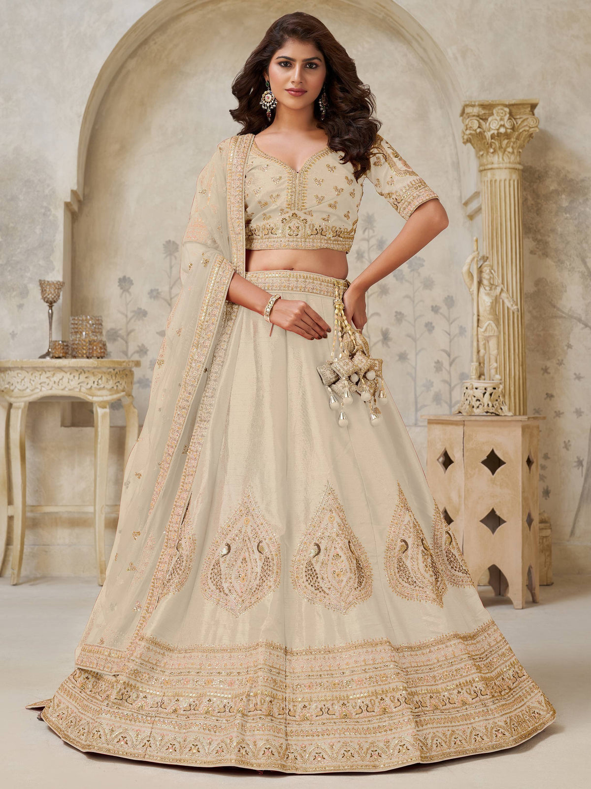 Cream embroidered lehenga choli with gold detailing, perfect for weddings and festive occasions