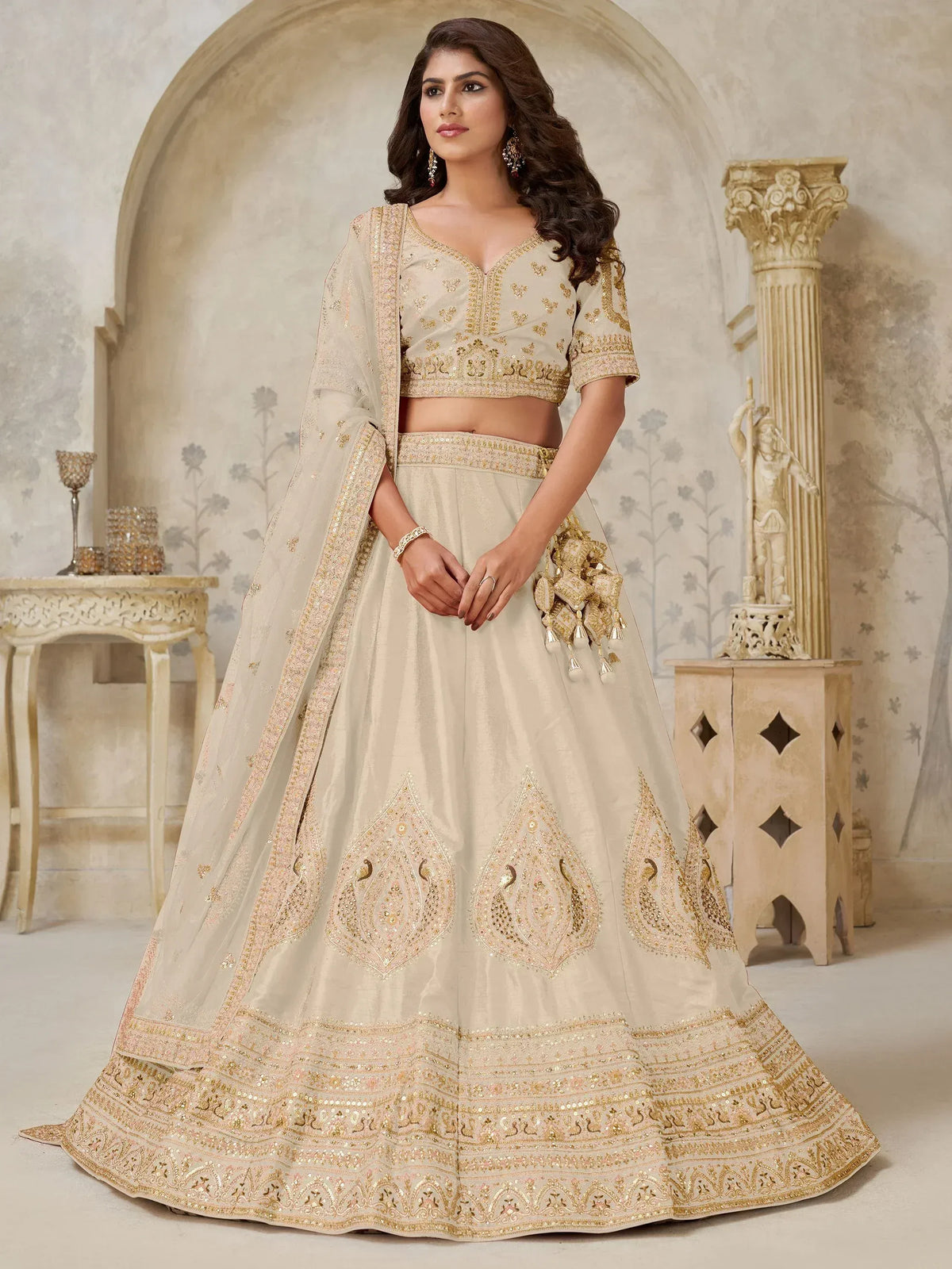 Elegant beige designer lehenga choli with gold embroidery and peacock motifs, perfect for Indian weddings.