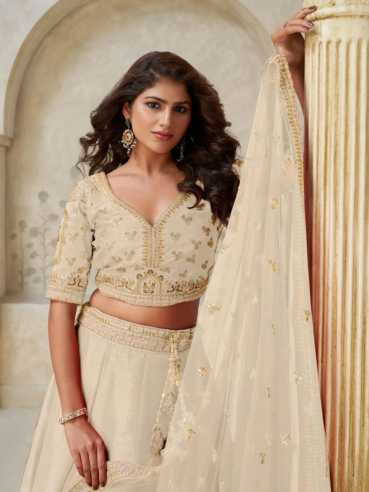 Cream embroidered lehenga choli with gold detailing, perfect for Indian ethnic wear and festive occasions.