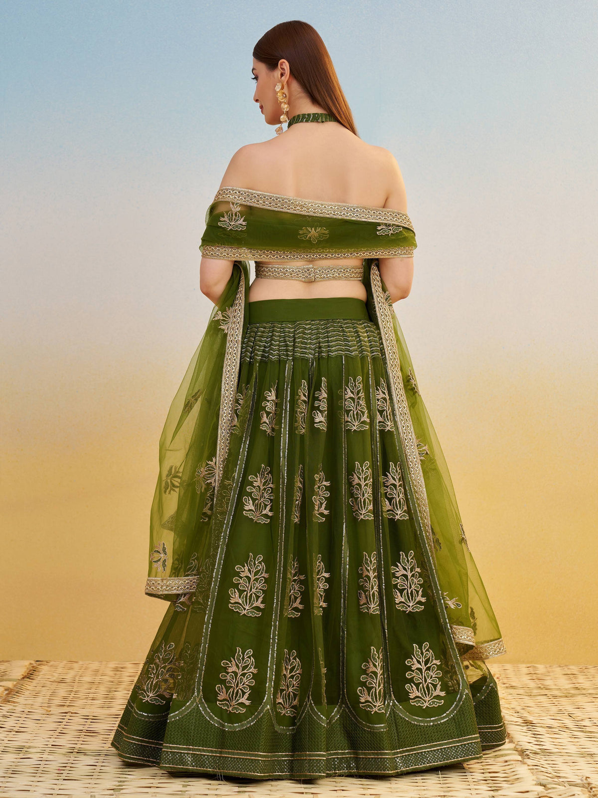 Green embroidered lehenga choli with off-shoulder blouse, perfect for Indian ethnic wear occasions.