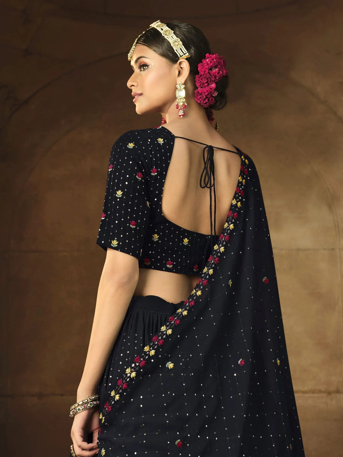 Black floral embroidered lehenga choli with open back, perfect for Indian ethnic wear occasions.