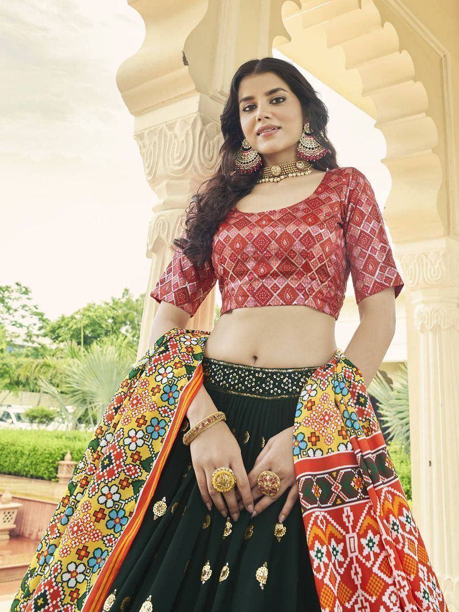 Woman in vibrant red and green ethnic lehenga choli with floral dupatta, traditional Indian wear