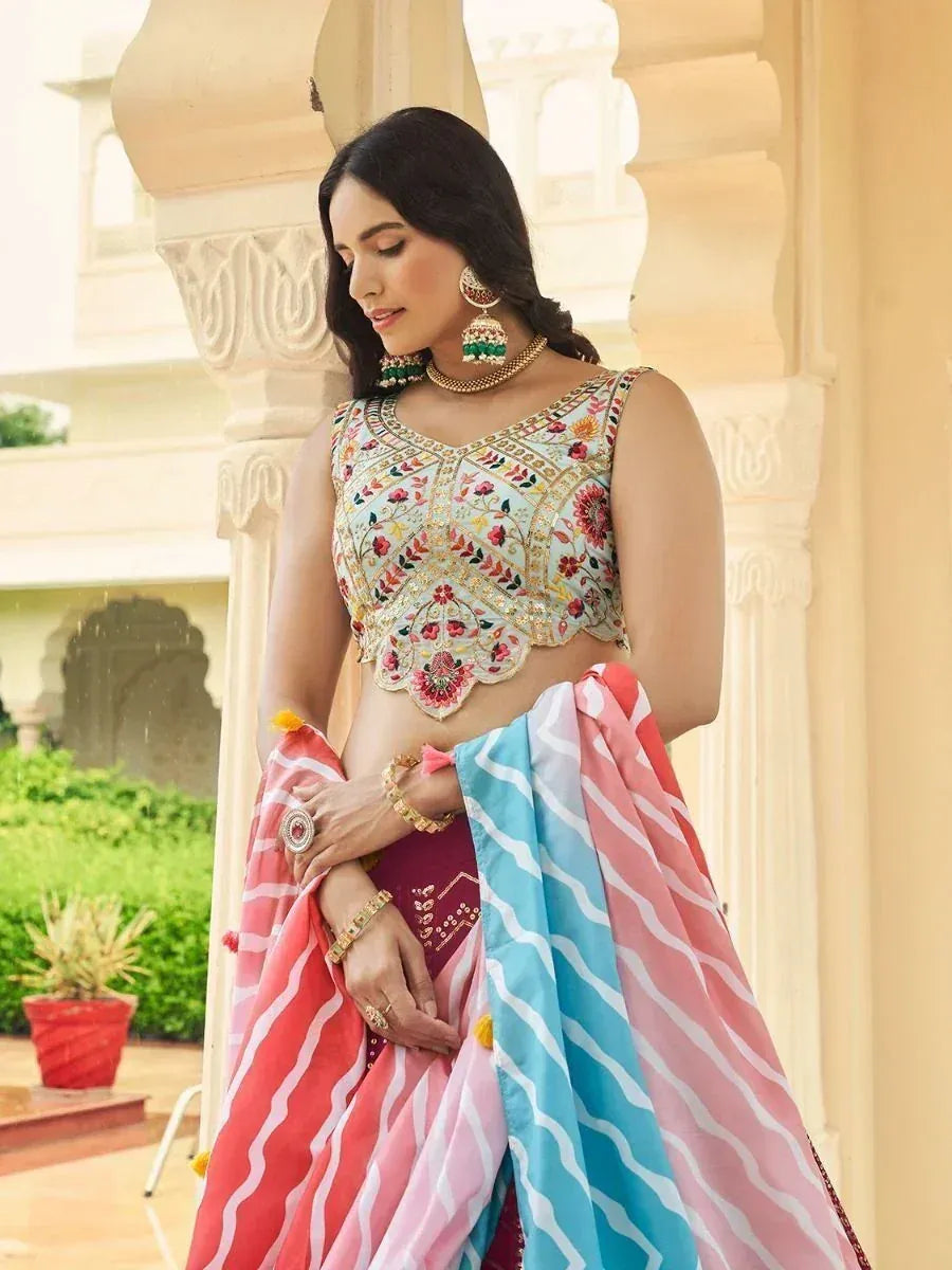 Woman in embroidered lehenga choli with colorful striped dupatta, traditional Indian ethnic wear