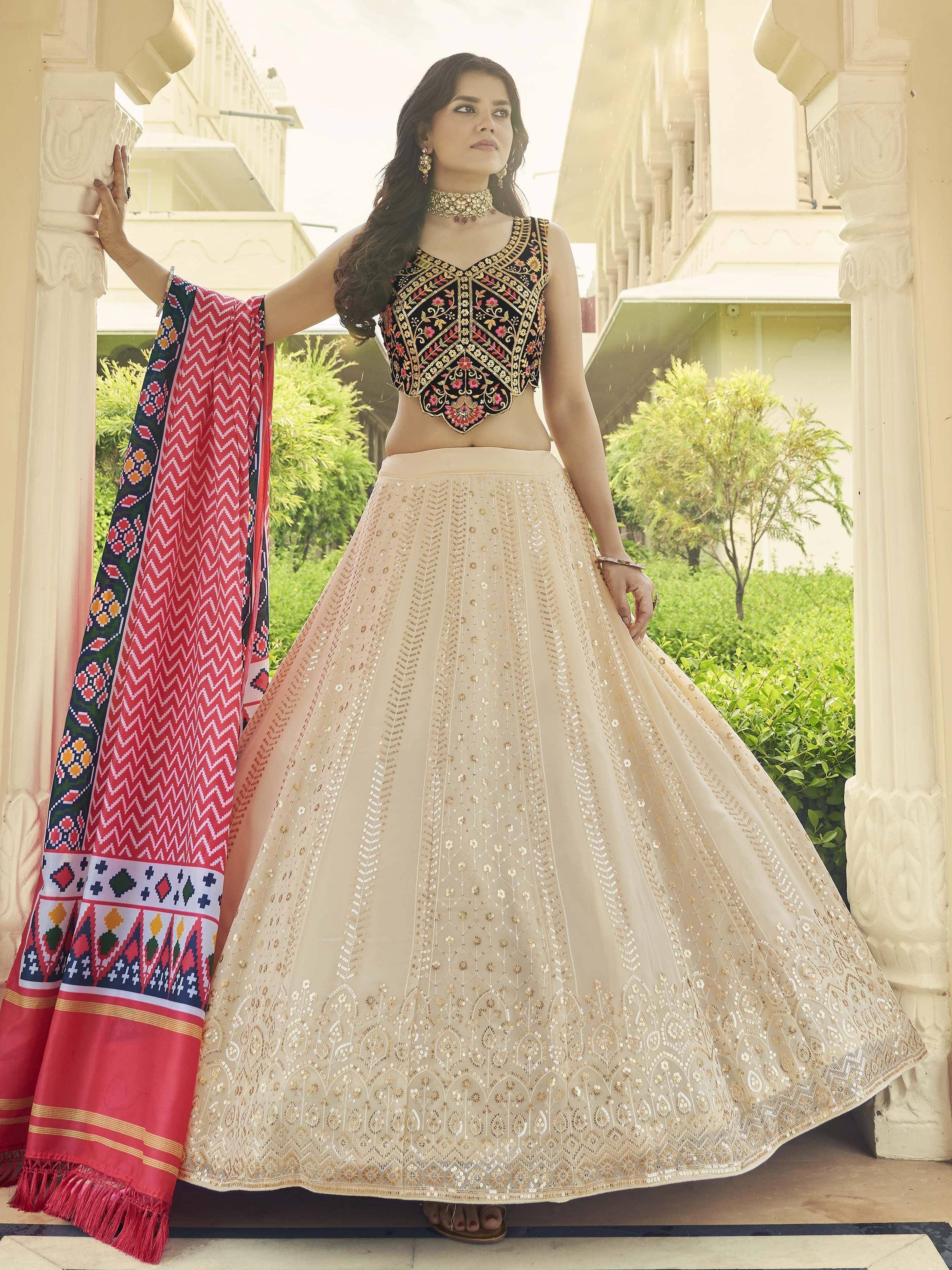 Woman in embroidered black blouse and beige lehenga with red dupatta, Indian ethnic wear