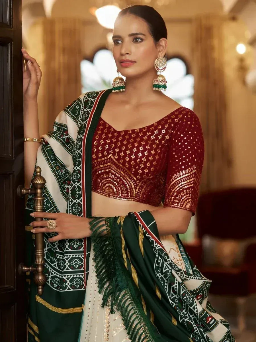Woman in maroon embroidered blouse with green and white patterned saree, traditional Indian ethnic wear