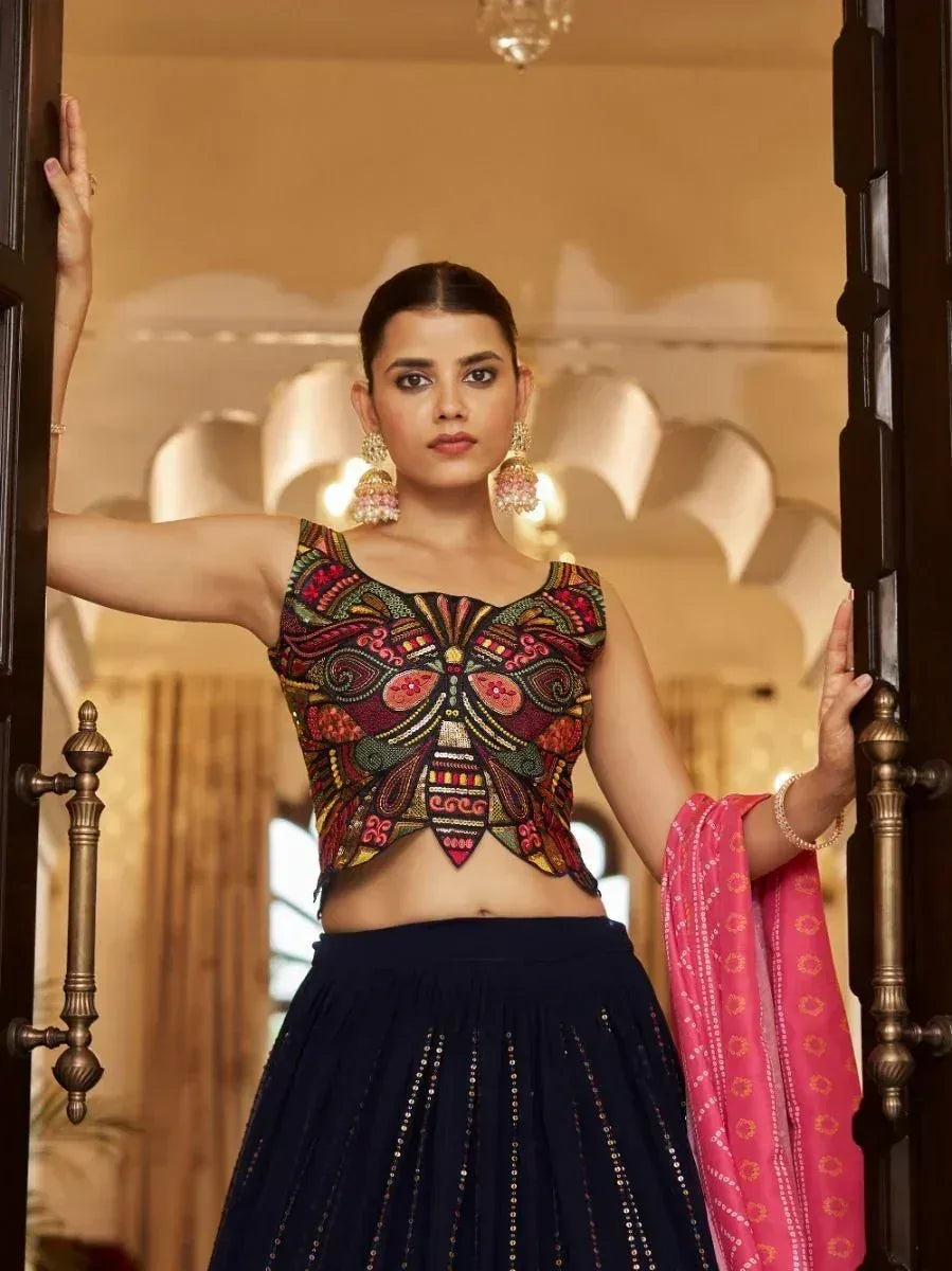 Indian ethnic lehenga choli with embroidered crop top and navy skirt, paired with pink dupatta
