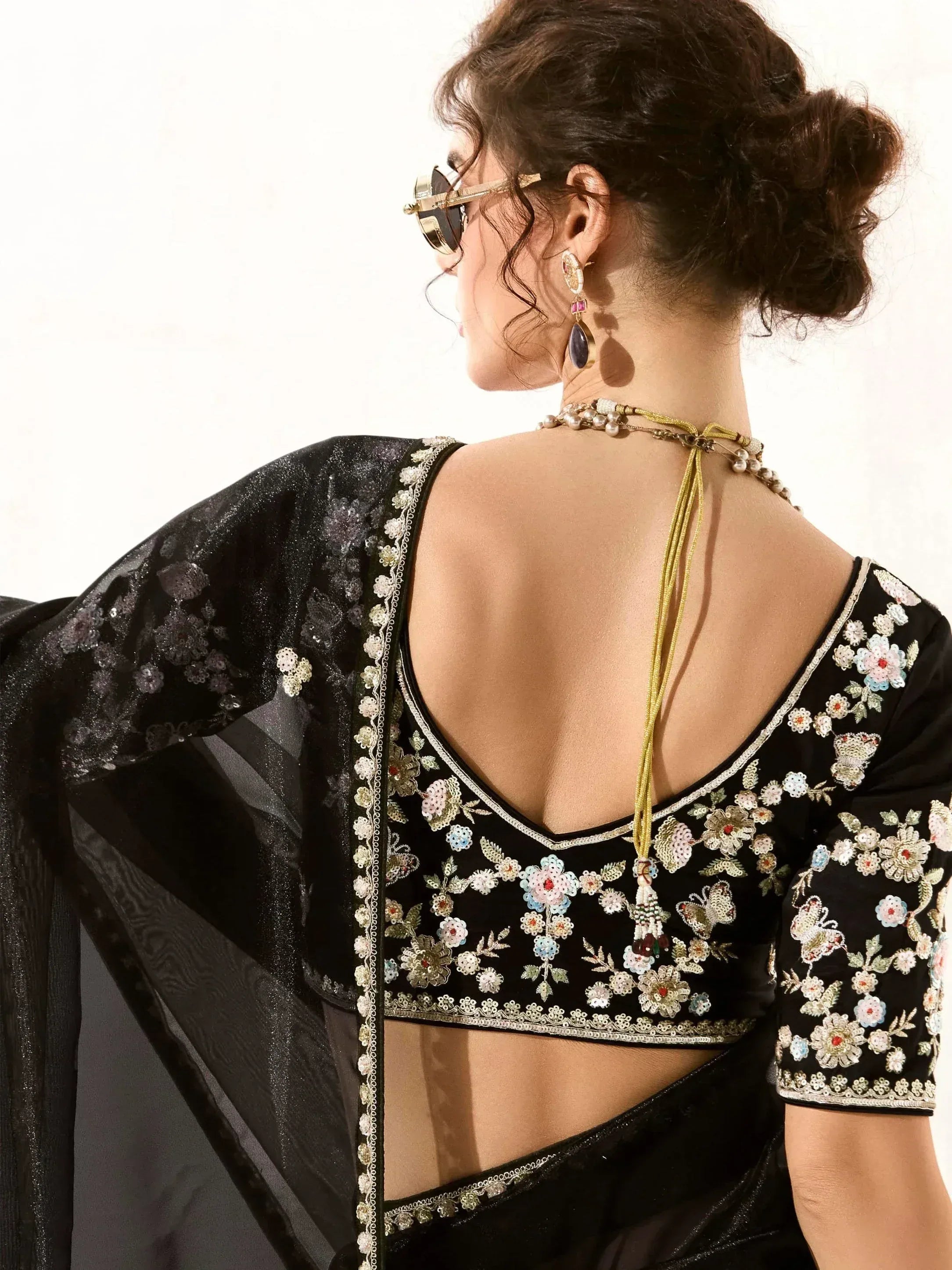 Black floral embroidered saree blouse with backless design and matching dupatta, styled with statement jewelry.