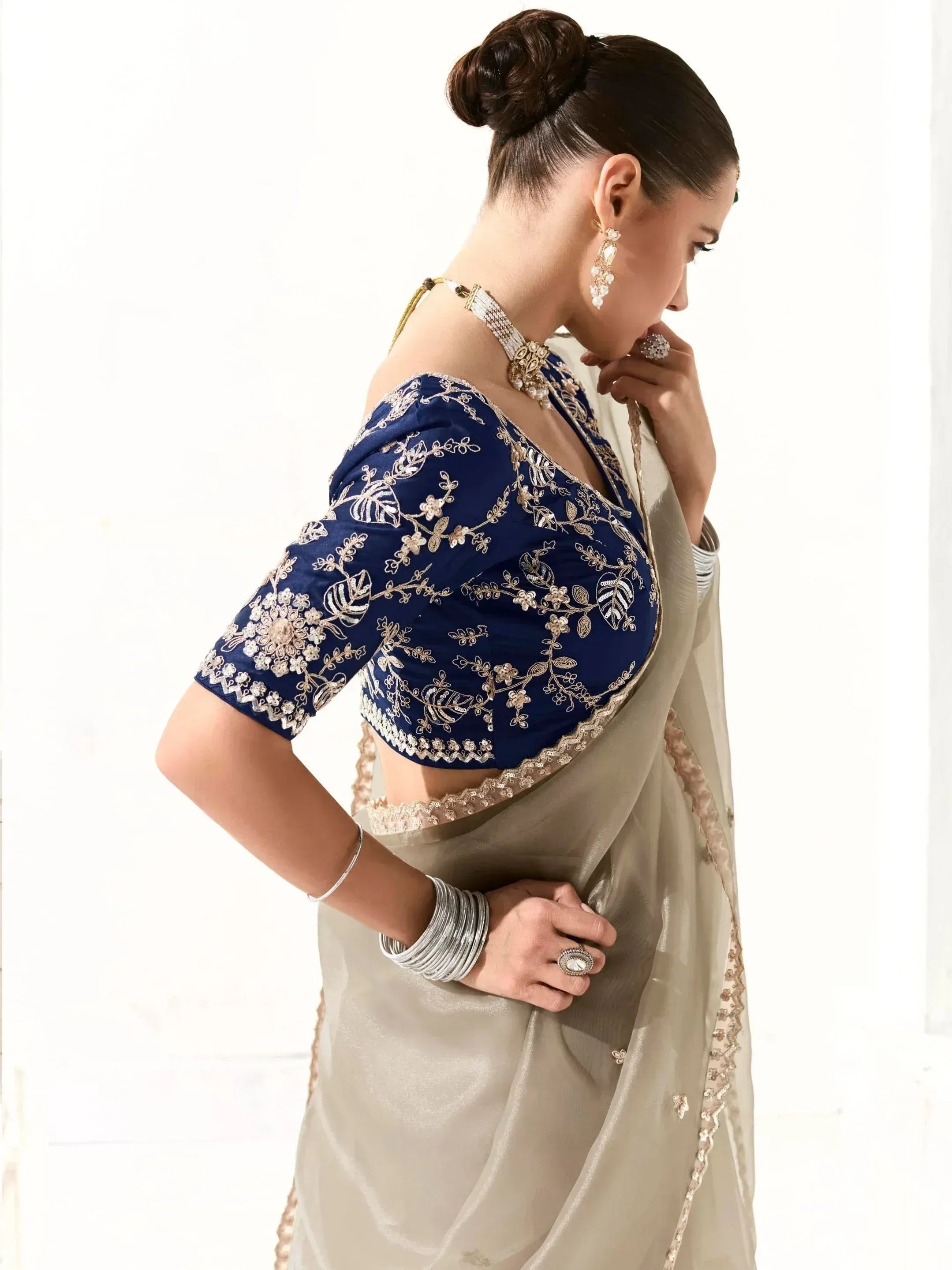 Woman in elegant beige saree with navy blue embroidered blouse, traditional Indian ethnic wear