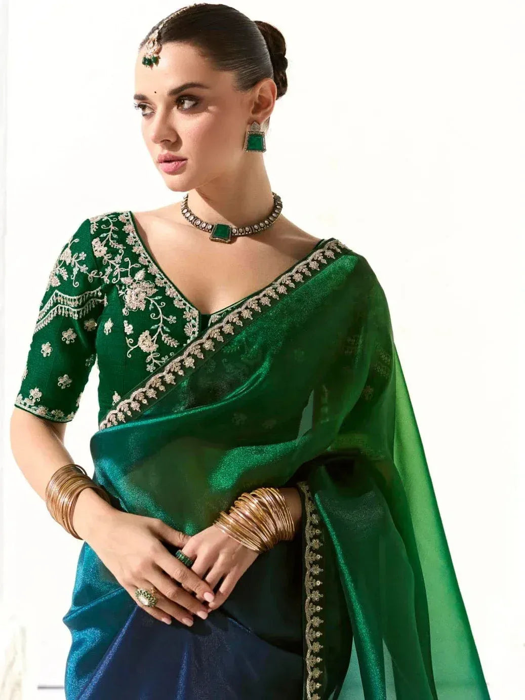 Emerald green designer saree with gold embroidery, perfect for Indian ethnic wear and festive occasions.