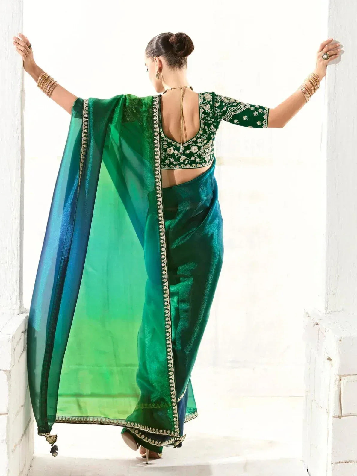 Emerald green designer saree with gold embroidery, backless blouse, and sheer dupatta for Indian ethnic wear