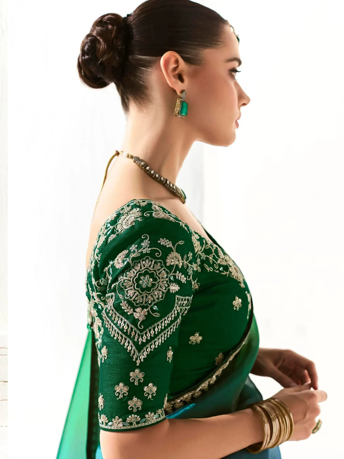 Emerald green saree blouse with gold floral embroidery, perfect for Indian ethnic wear occasions.