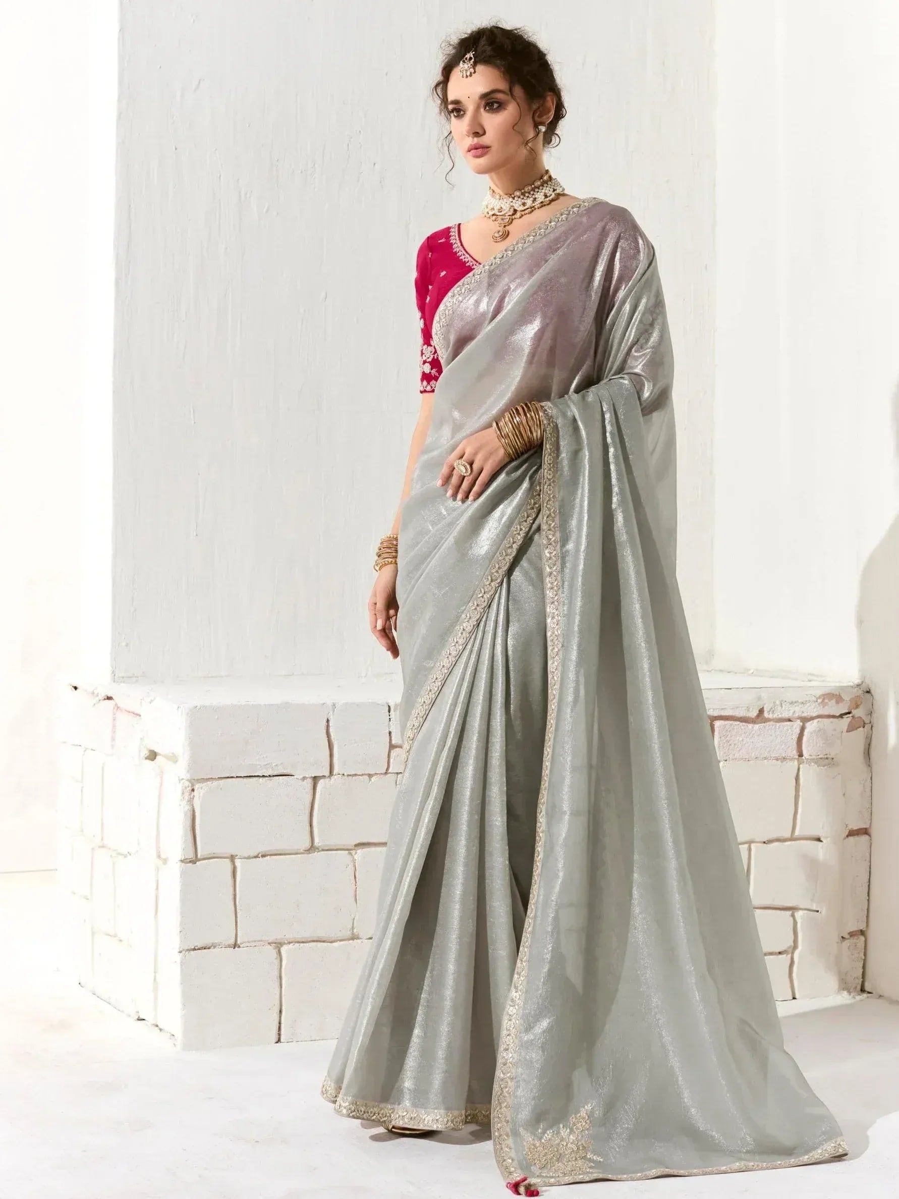 Elegant silver shimmer saree with gold border, paired with pink embroidered blouse, perfect for Indian ethnic occasions.