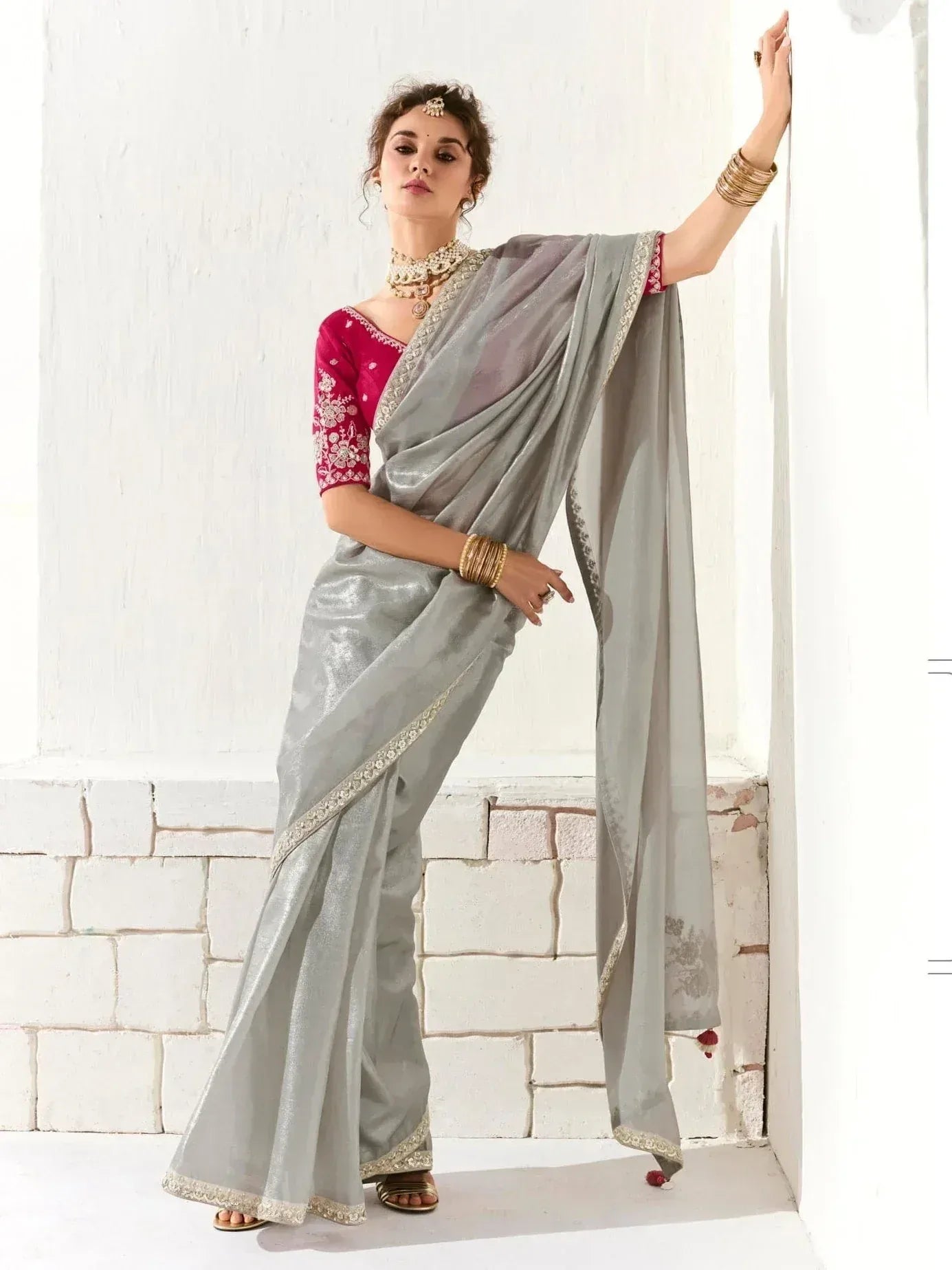 Grey saree with gold border and red embroidered blouse, styled with traditional jewelry for Indian ethnic wear