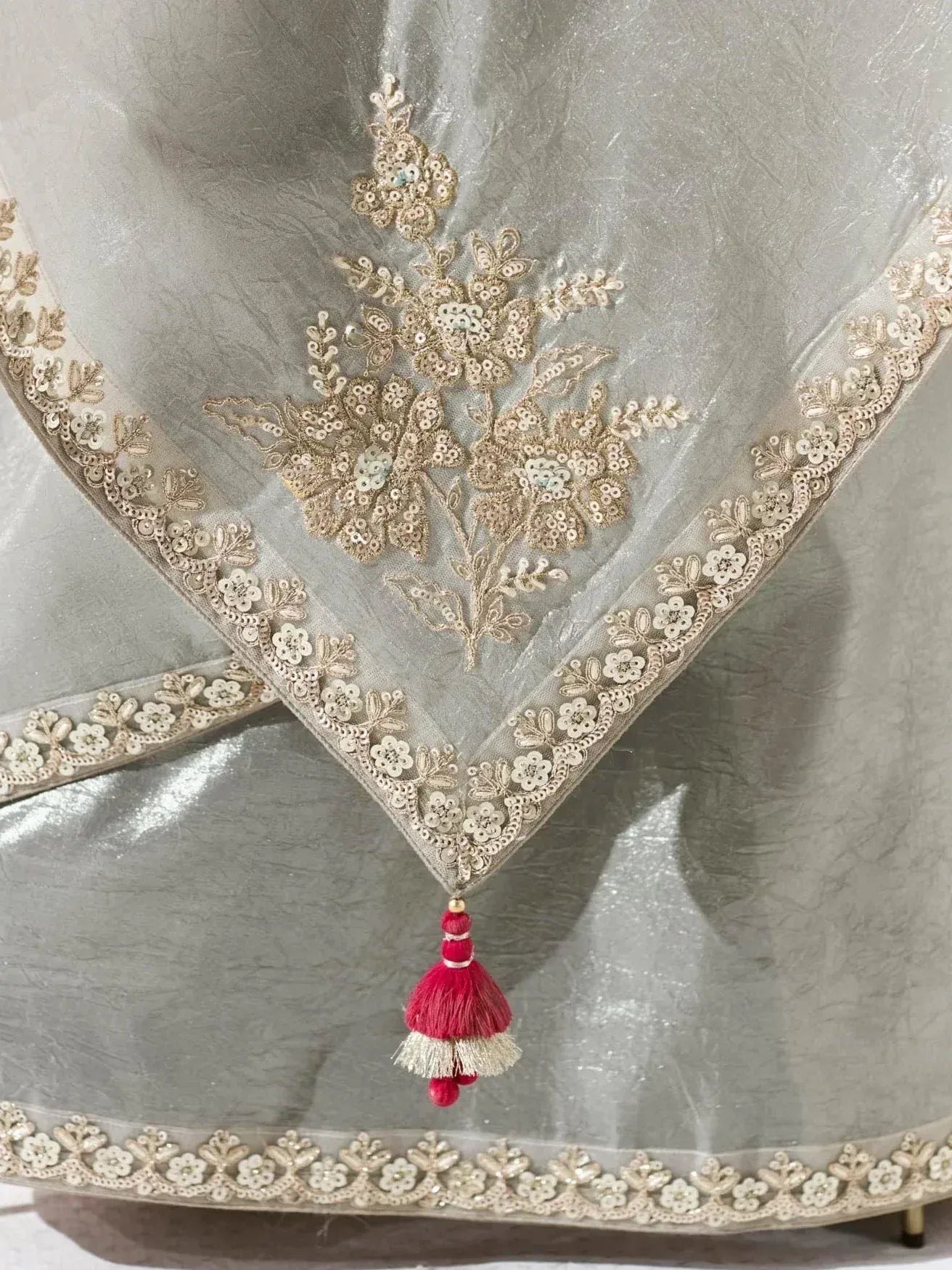 Silver ethnic gown with gold floral embroidery and red tassel detail
