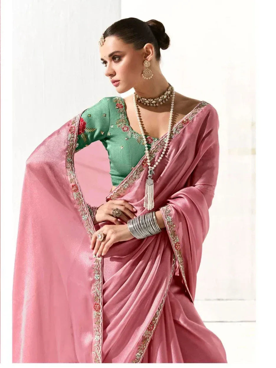 Pink silk saree with floral embroidery and green blouse, styled with traditional Indian jewelry for ethnic wear.