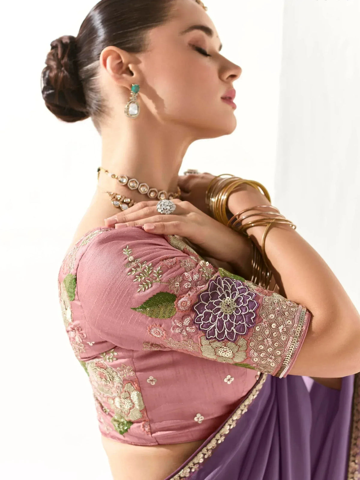 Pink embroidered blouse with floral design paired with purple saree, traditional Indian ethnic wear