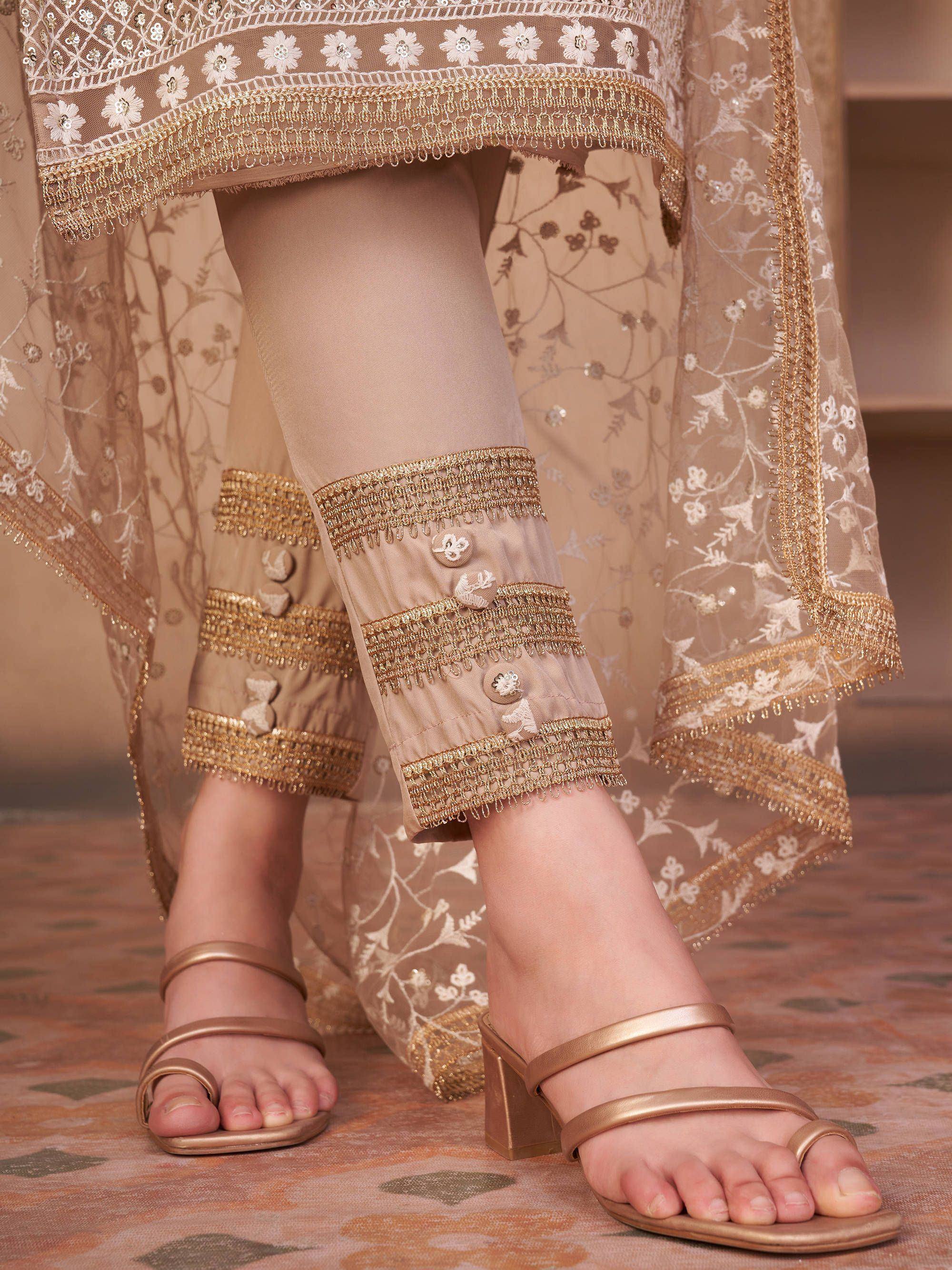 Embroidered beige ethnic kurta set with gold detailing and floral net dupatta