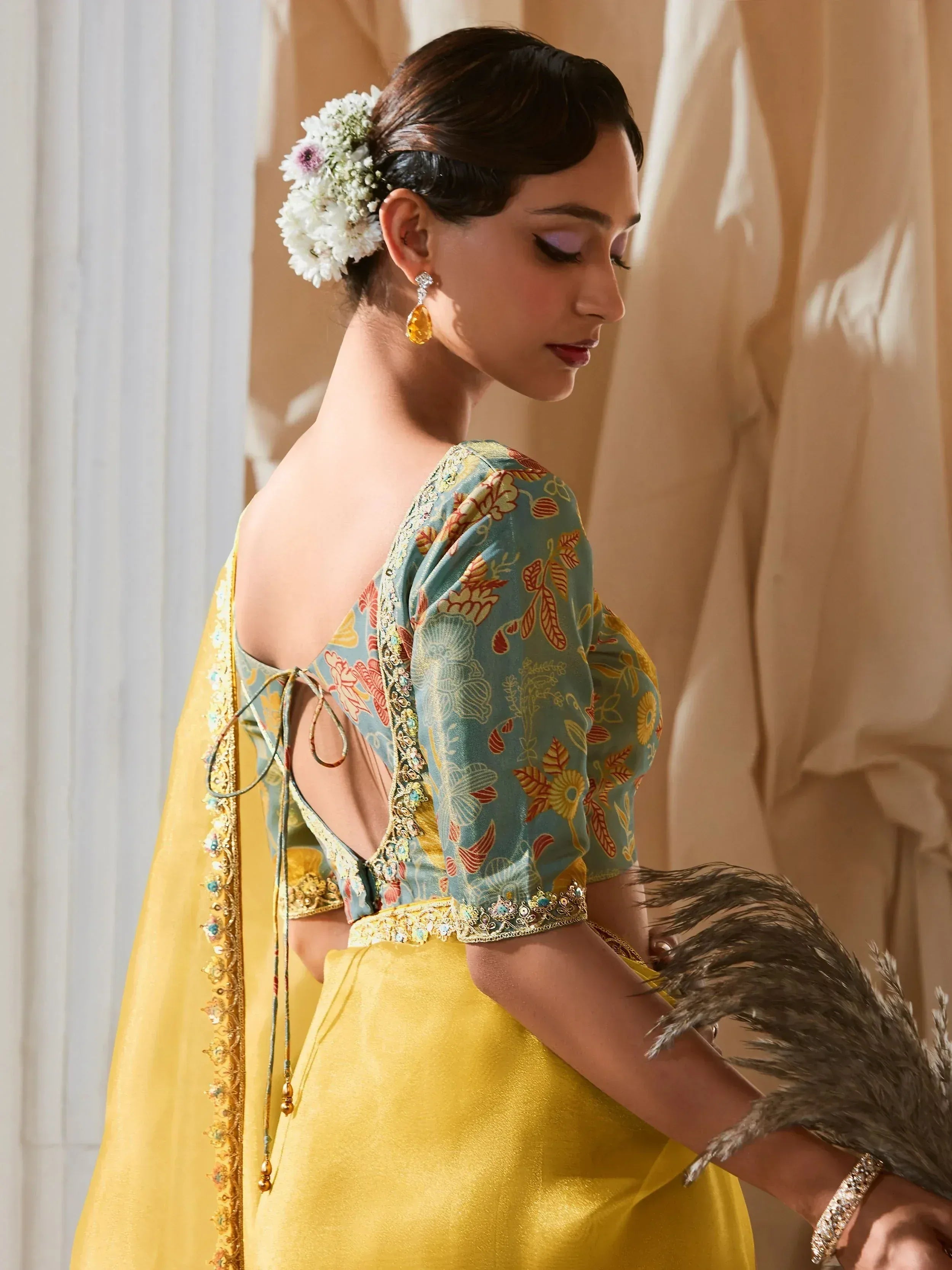 Elegant Indian ethnic wear with floral print blouse, yellow skirt, and floral hair accessory
