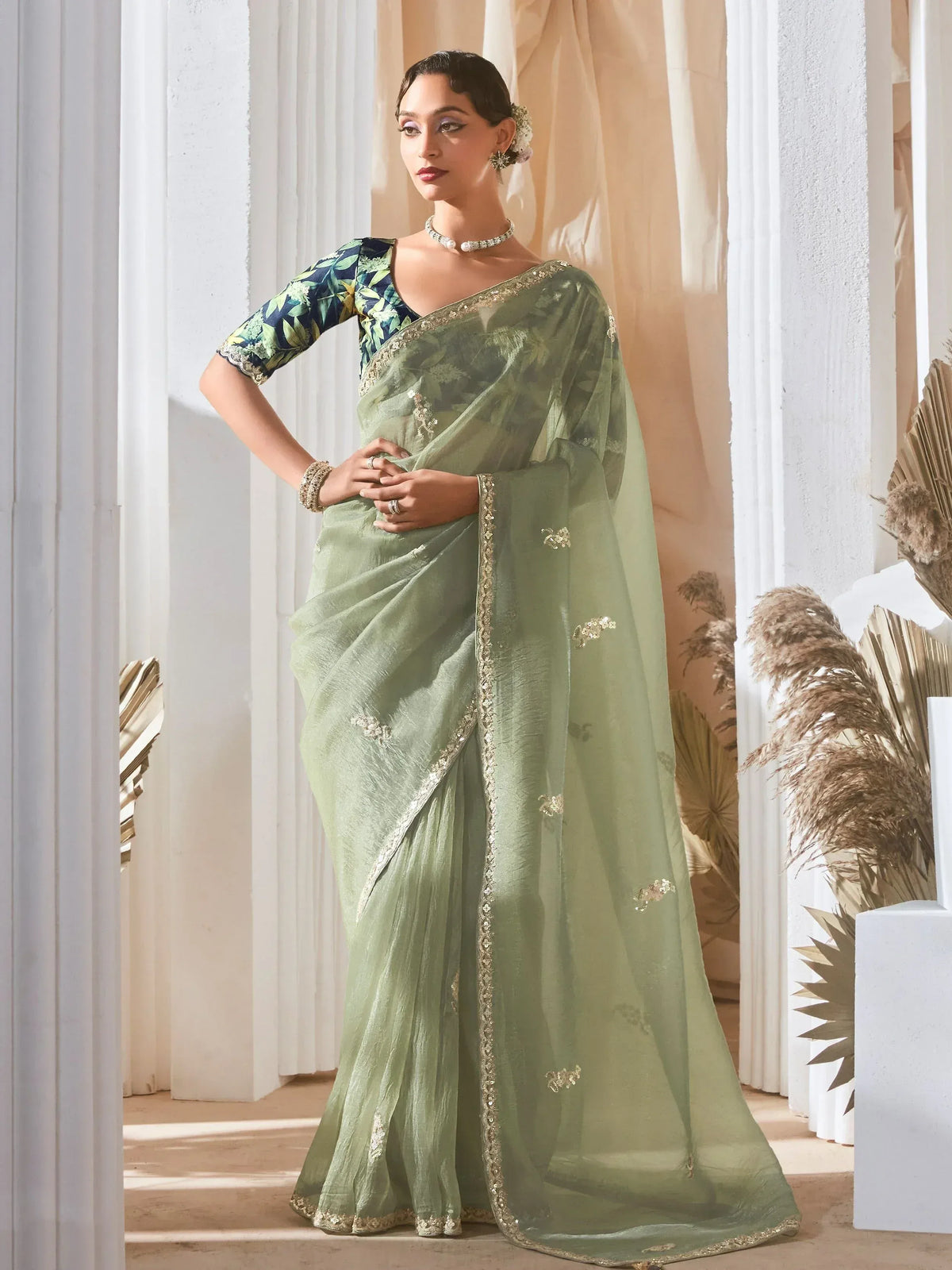 Elegant light green saree with gold embroidery and floral blouse, perfect for Indian ethnic occasions.