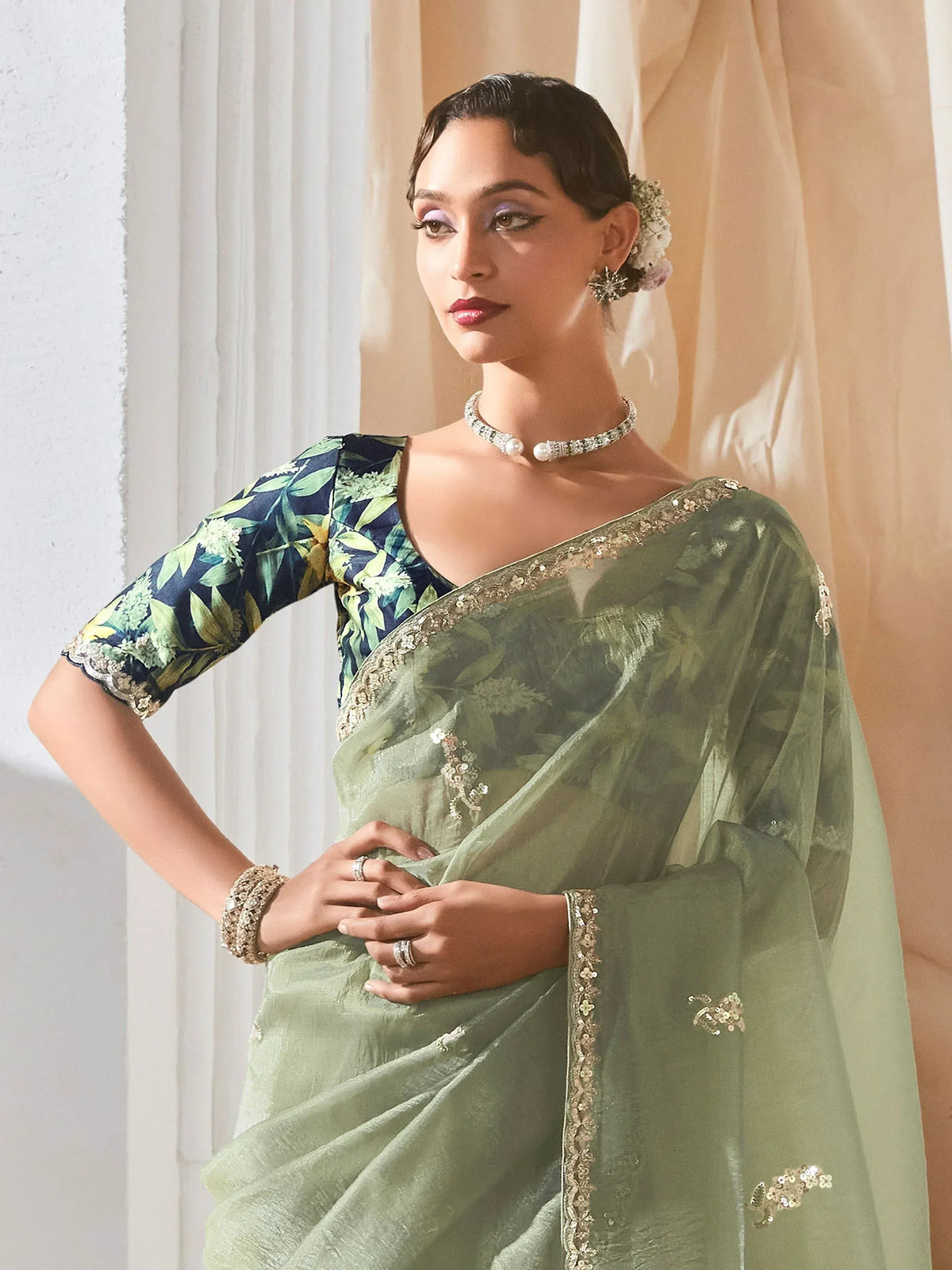 Elegant green saree with floral blouse and gold embroidery, perfect for Indian ethnic occasions.