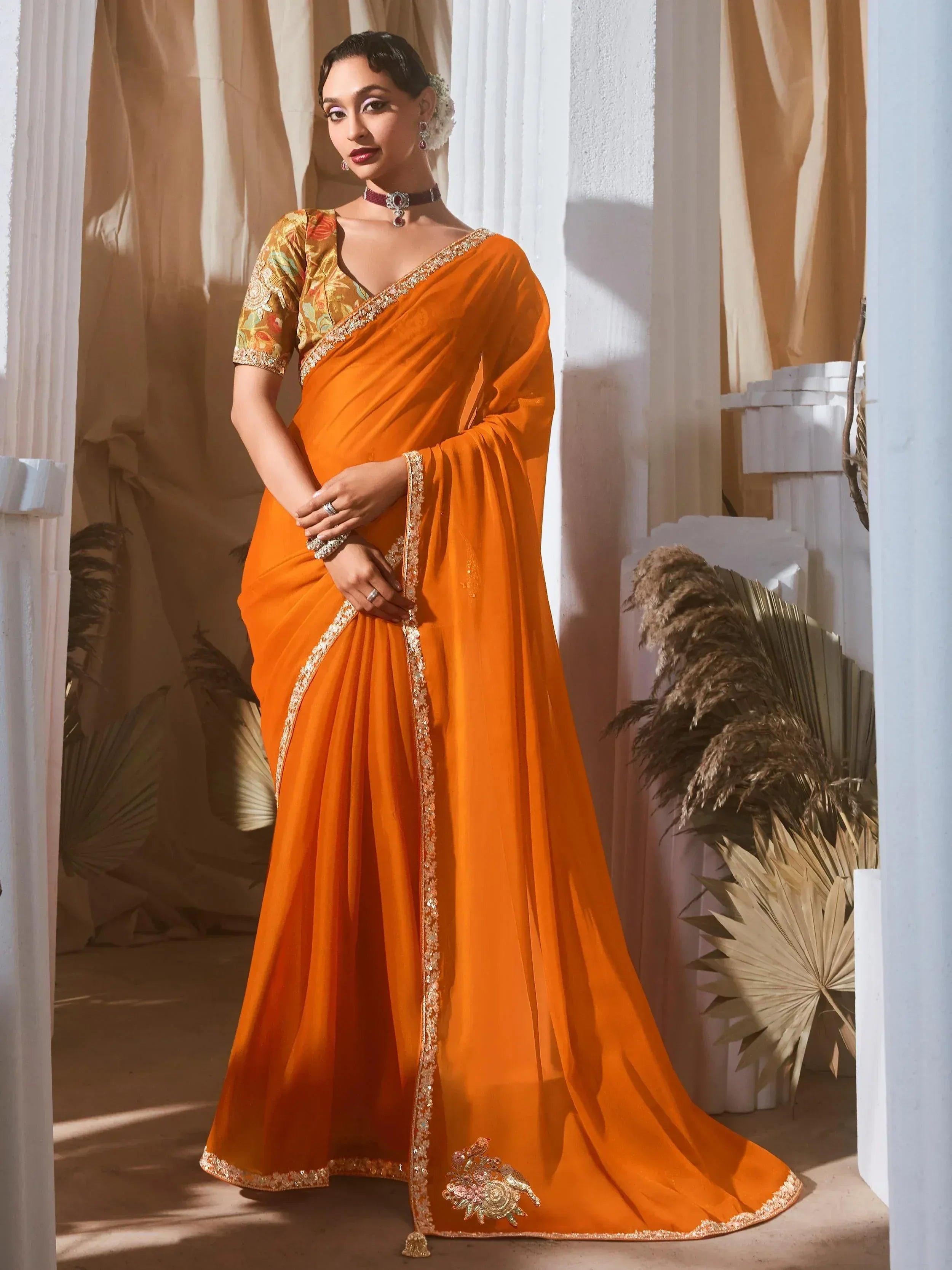 Vibrant orange designer saree with gold embroidery and floral blouse, perfect for Indian ethnic occasions
