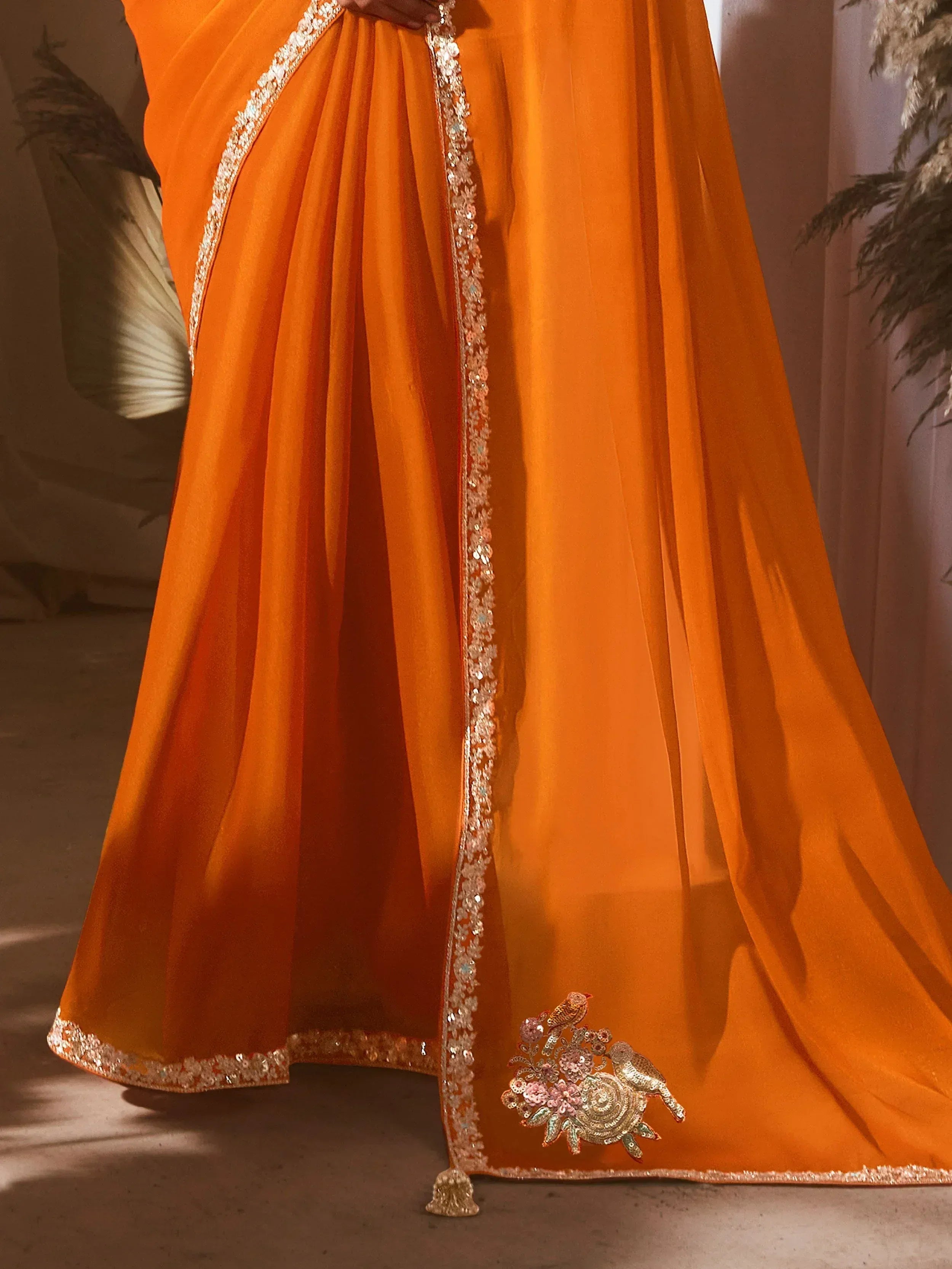 Orange ethnic gown with floral bird embroidery and sequin border, perfect for Indian celebrations