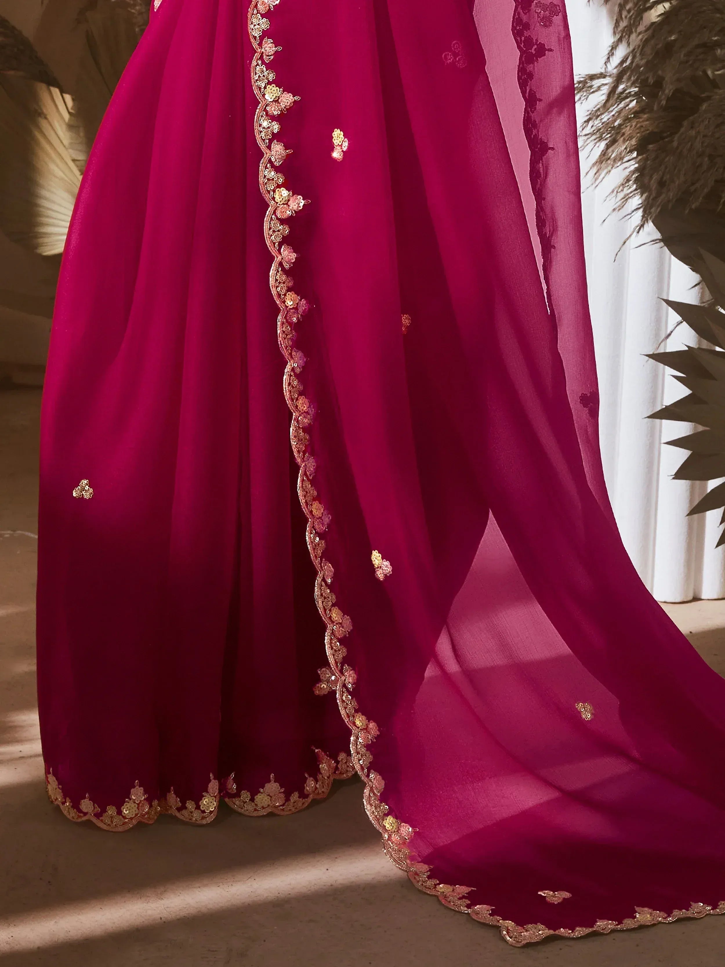 Fuchsia Indian ethnic gown with gold floral embroidery and sheer dupatta, perfect for weddings or festive occasions.