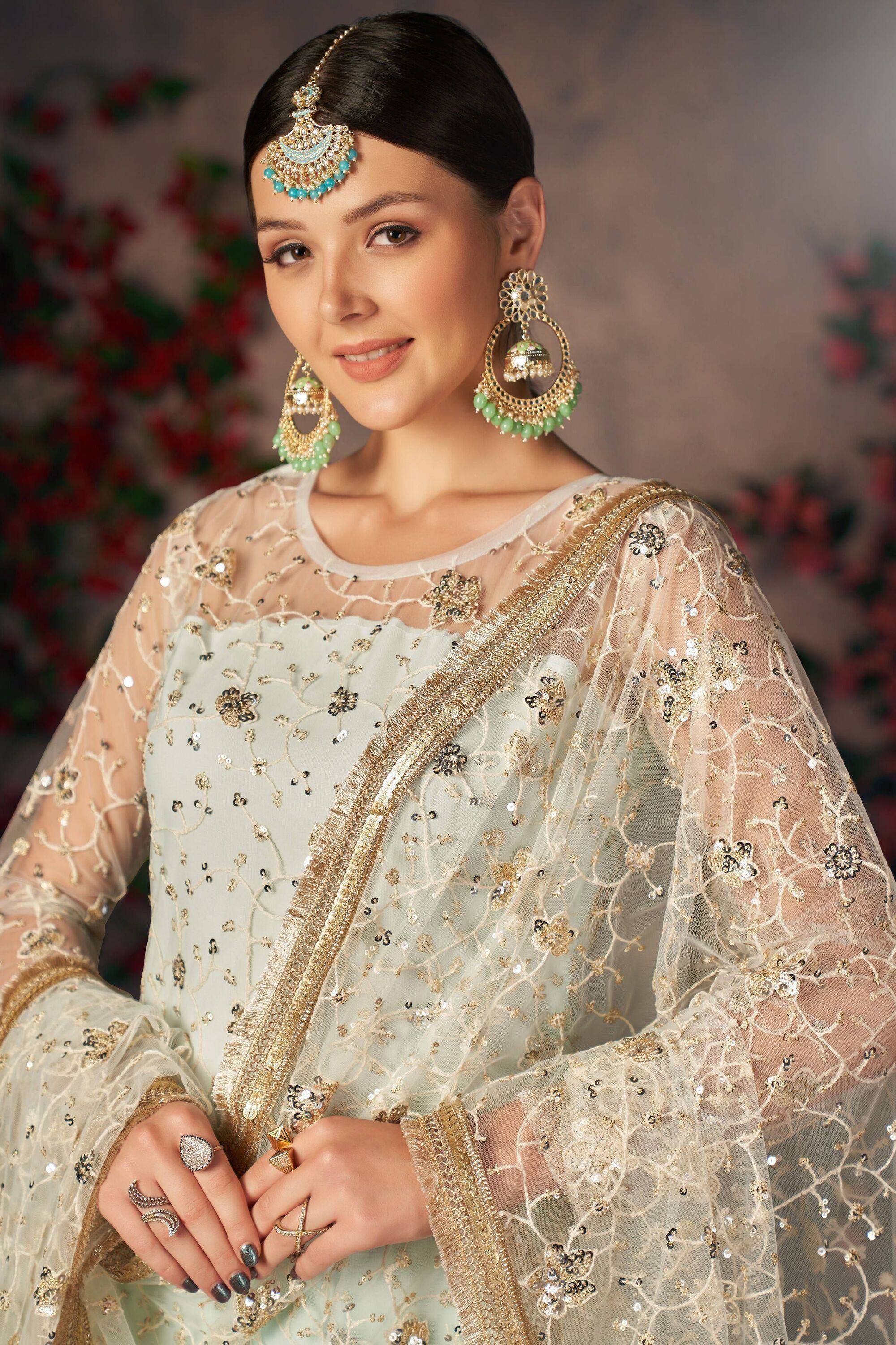 Elegant Indian ethnic wear with gold embroidery, sheer dupatta, and traditional jewelry for festive occasions