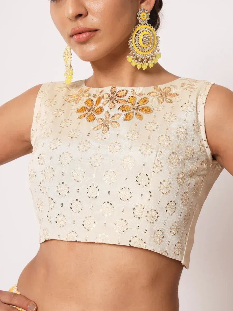 Cream embroidered crop top with floral motifs, paired with yellow statement earrings for ethnic wear