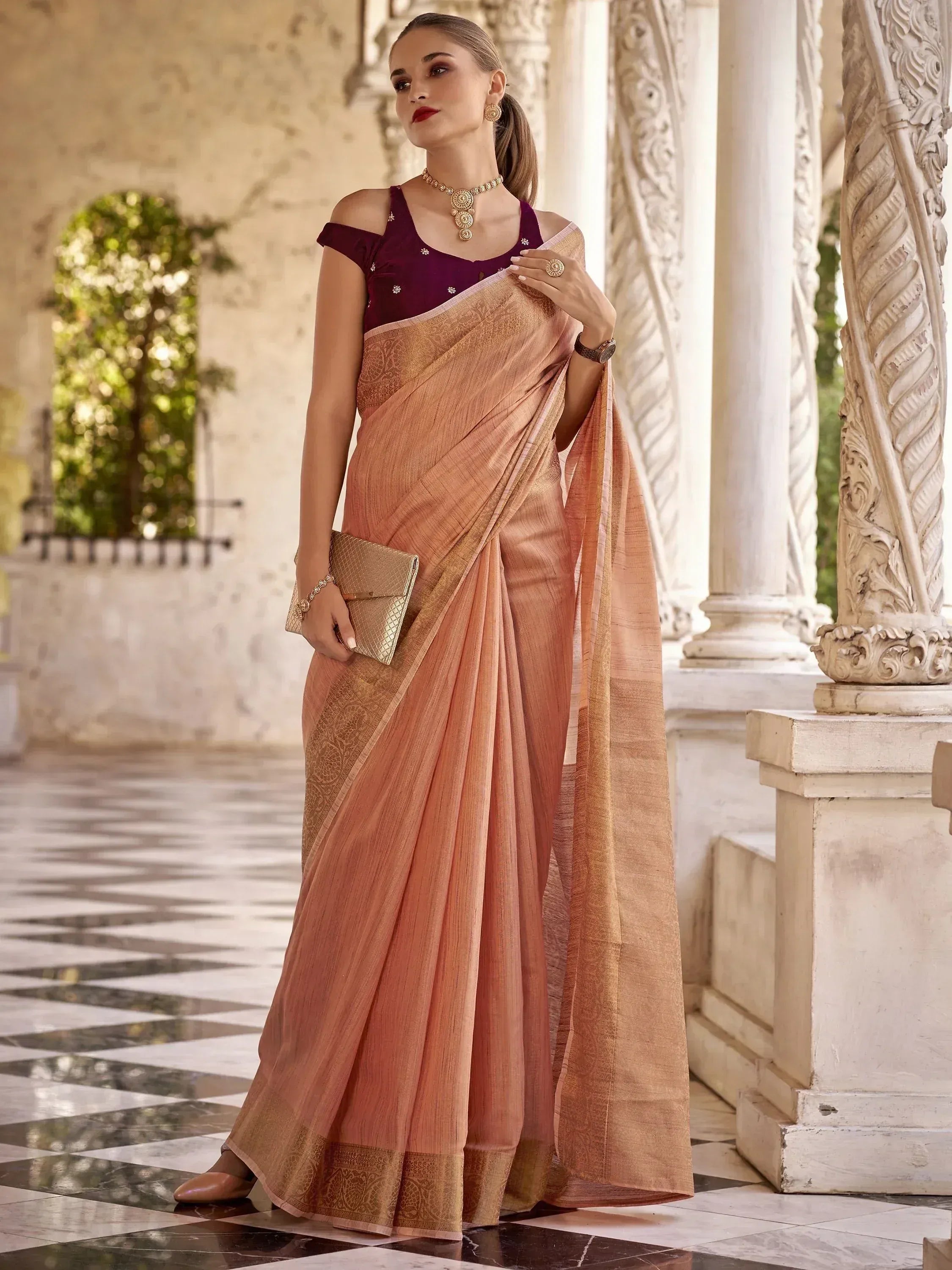 Elegant peach saree with gold border, paired with maroon blouse, perfect for Indian ethnic occasions
