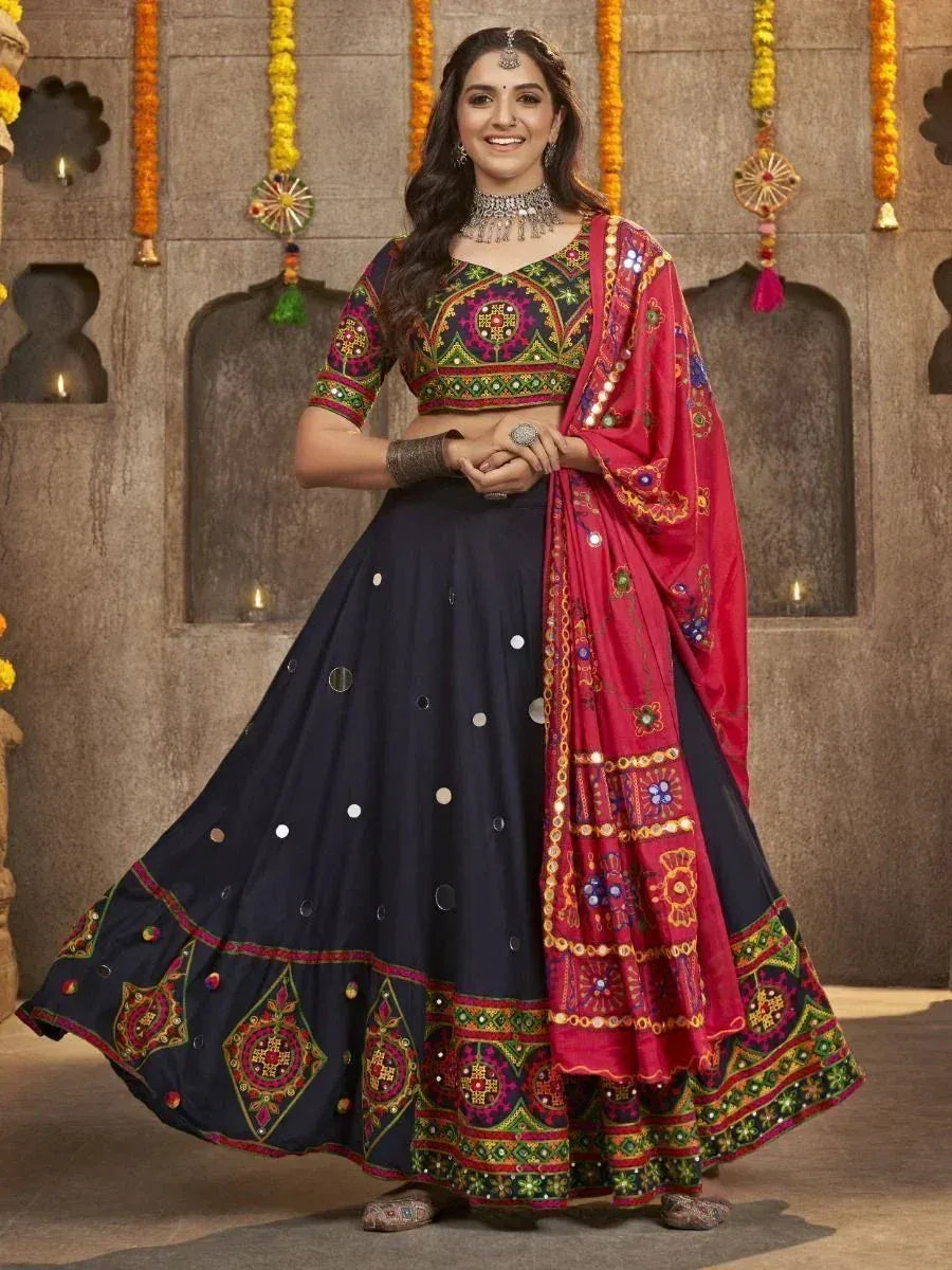 Woman in vibrant Indian lehenga choli with mirror work, floral embroidery, and red dupatta, perfect for festive occasions.