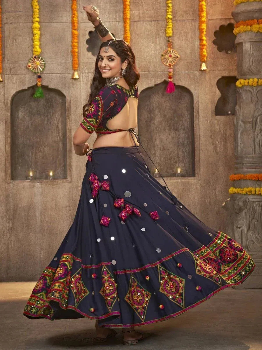 Woman dancing in navy blue embroidered lehenga choli with mirror work, perfect for Indian ethnic occasions
