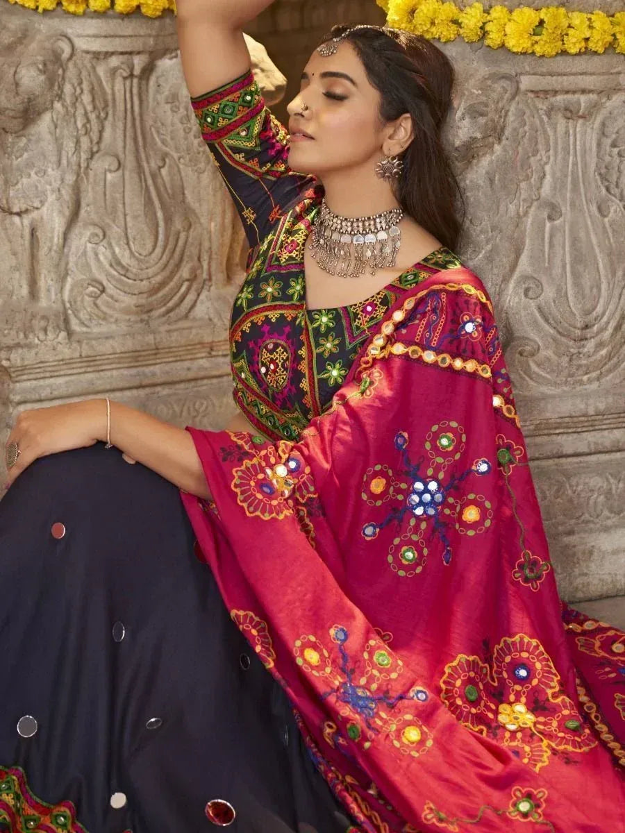Woman in vibrant embroidered lehenga choli with mirror work, traditional Indian ethnic wear