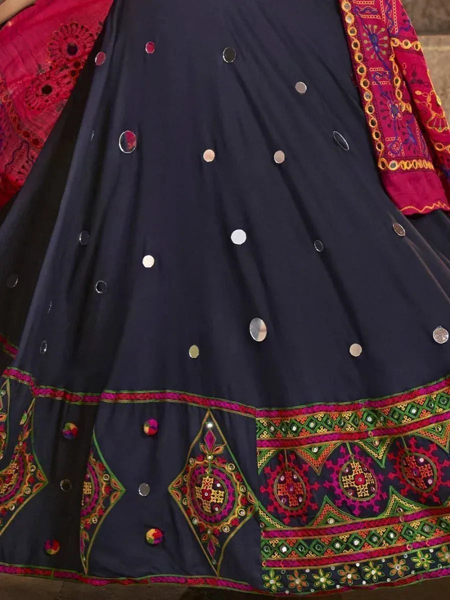 Navy blue ethnic lehenga with mirror work, colorful embroidery, and pom-poms, paired with red dupatta