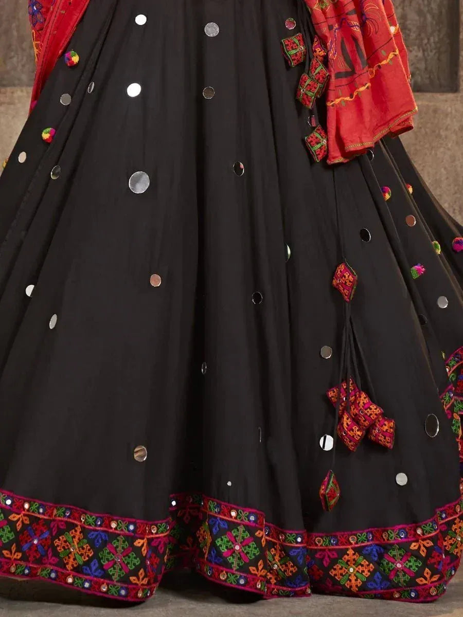 Black ethnic lehenga with mirror work, colorful embroidery, and red dupatta for festive occasions