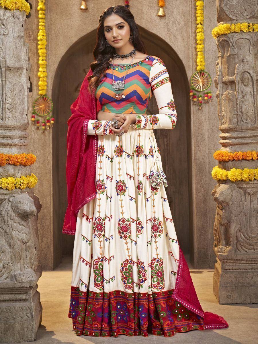 Woman in colorful embroidered Indian anarkali suit with red dupatta, traditional temple backdrop