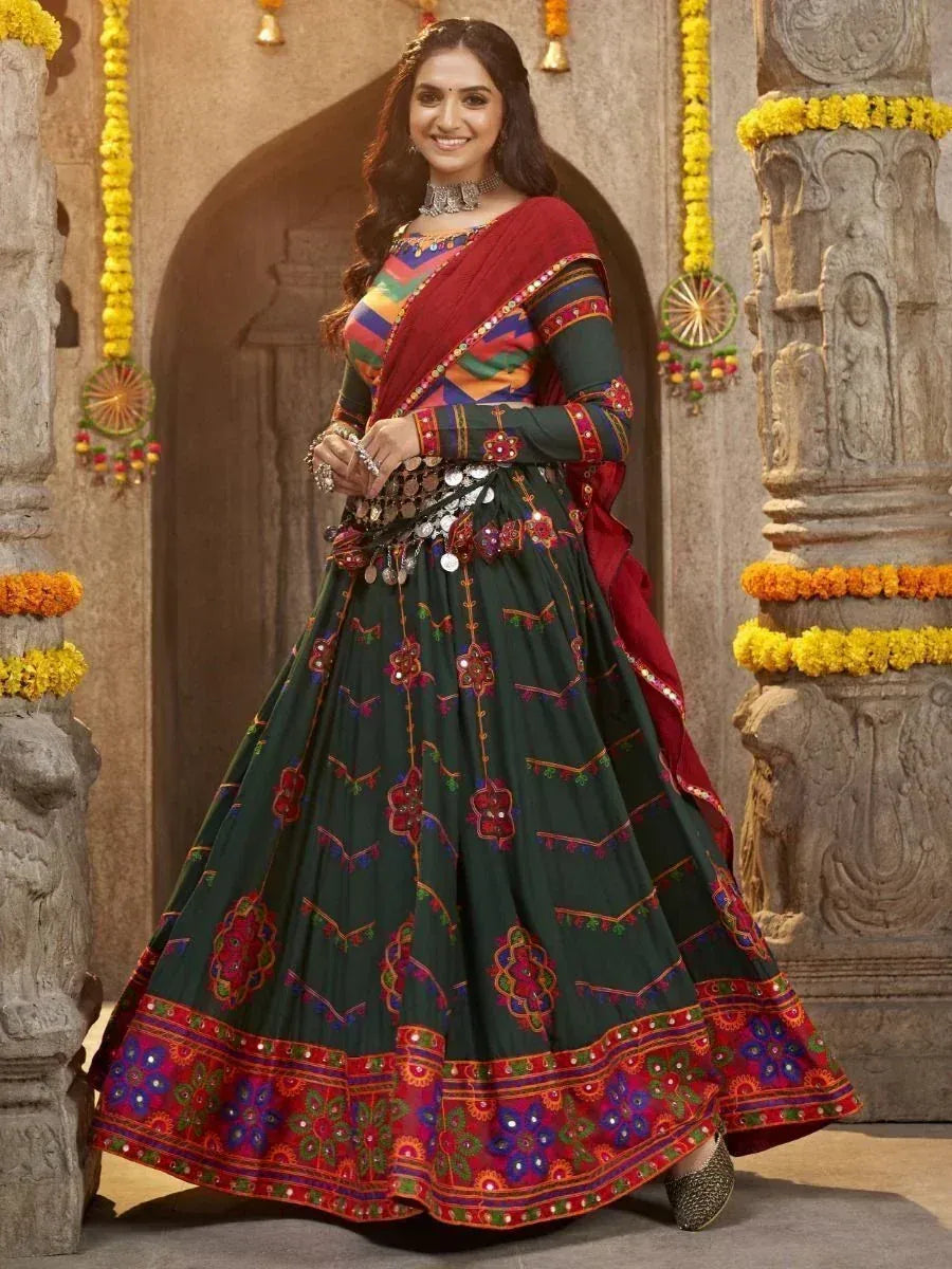 Woman in vibrant green and red embroidered lehenga choli with mirror work, traditional Indian ethnic wear