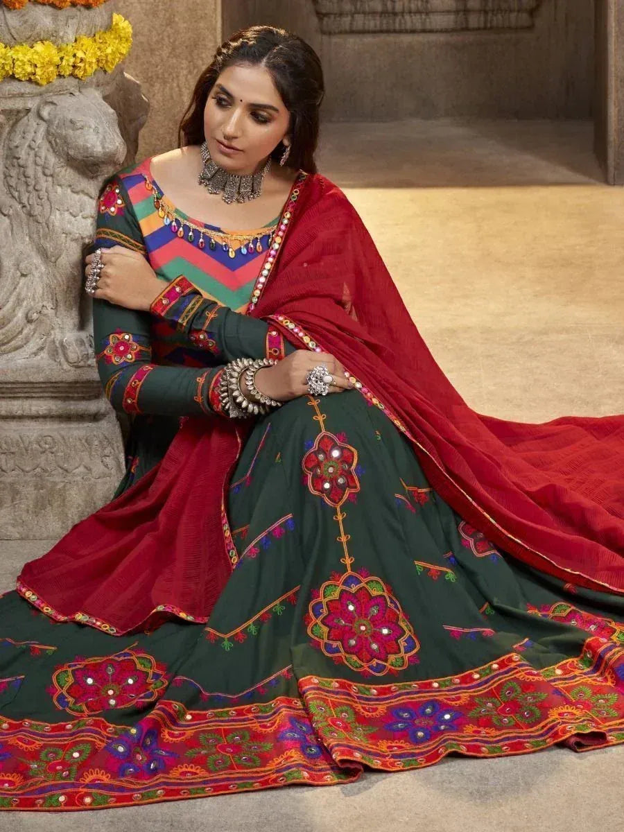 Woman in vibrant green and red embroidered lehenga choli with mirror work, traditional Indian ethnic wear