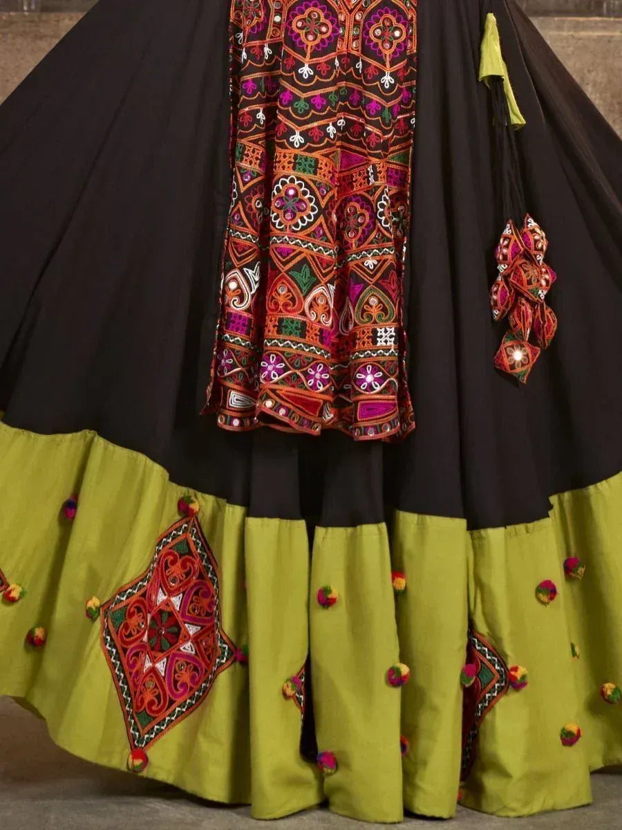 Black and lime green embroidered lehenga choli with colorful mirror work and pom poms