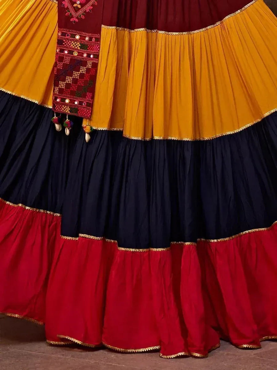 Vibrant Indian lehenga with layered mustard, navy, and red skirt, embroidered dupatta, gold trim details